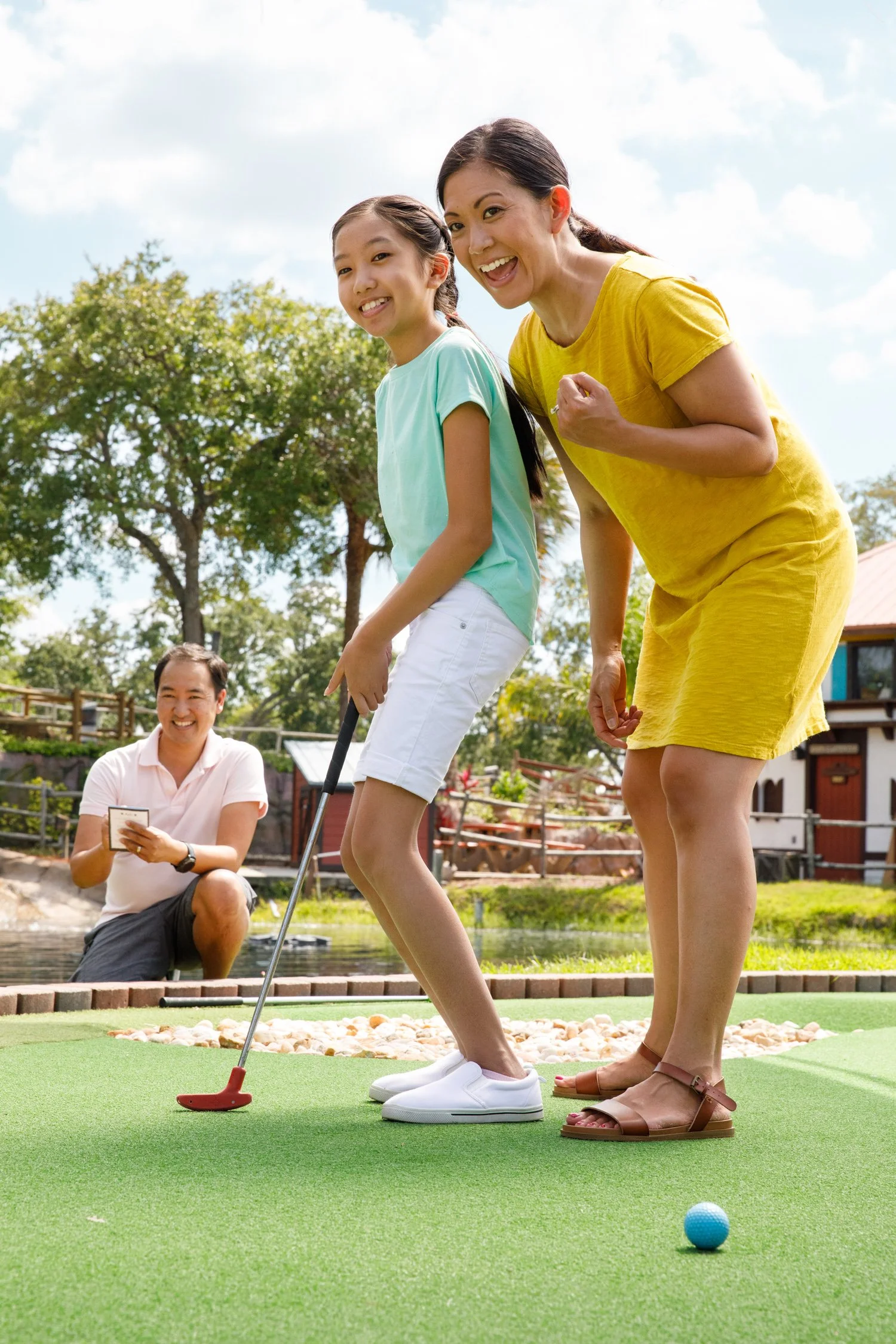 photograph of asian family playing mini golf