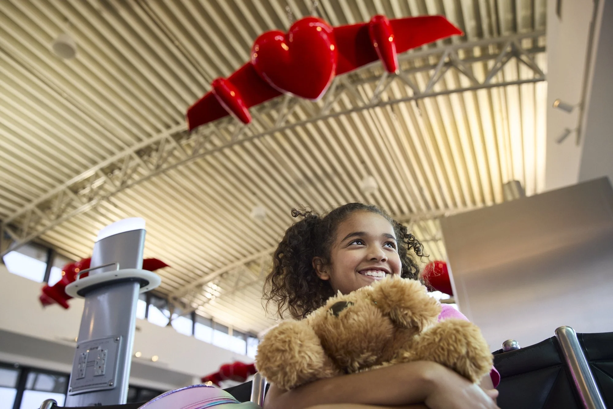 girl holding teddy bear at tampa international airport