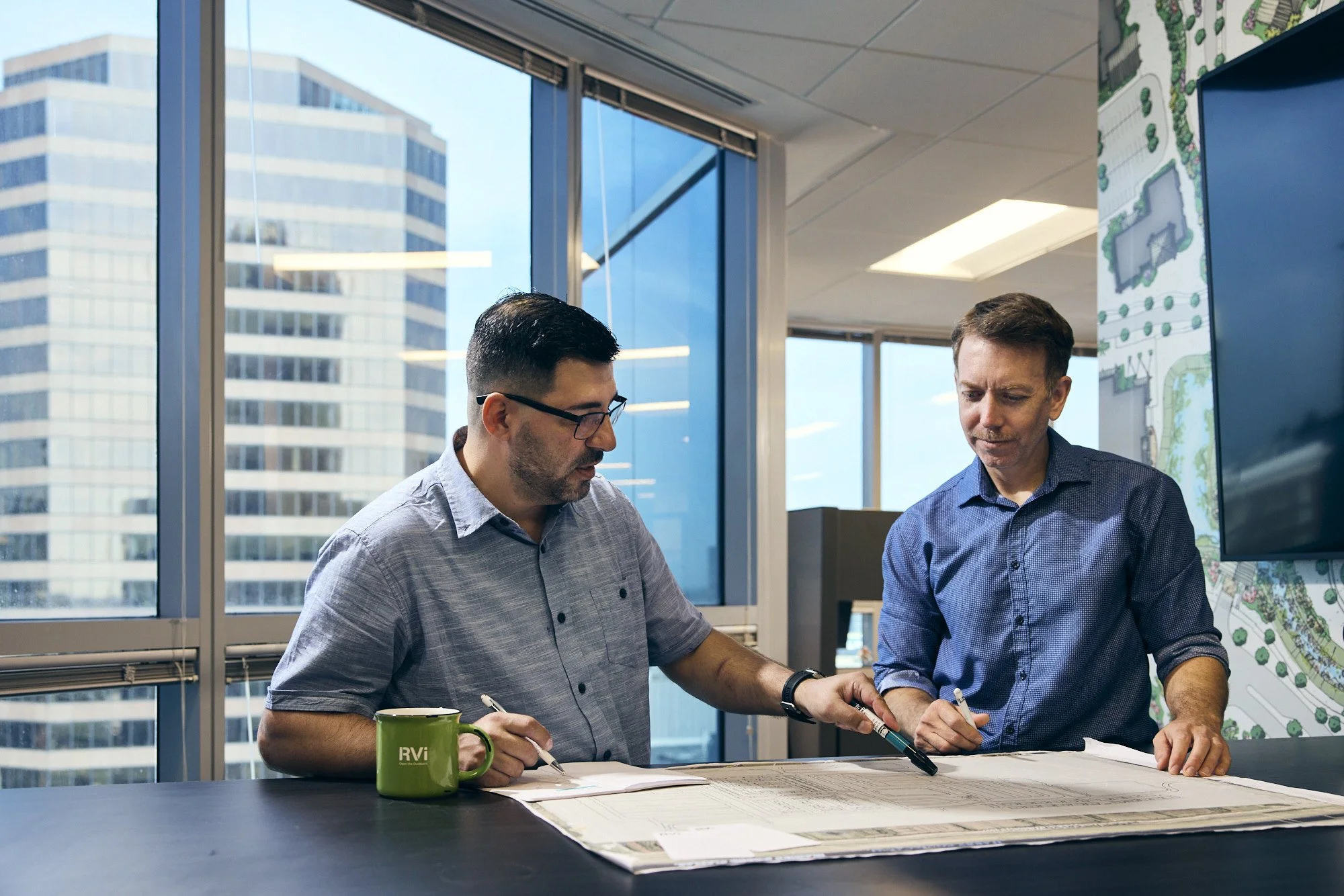 photograph of men working on architecture plans