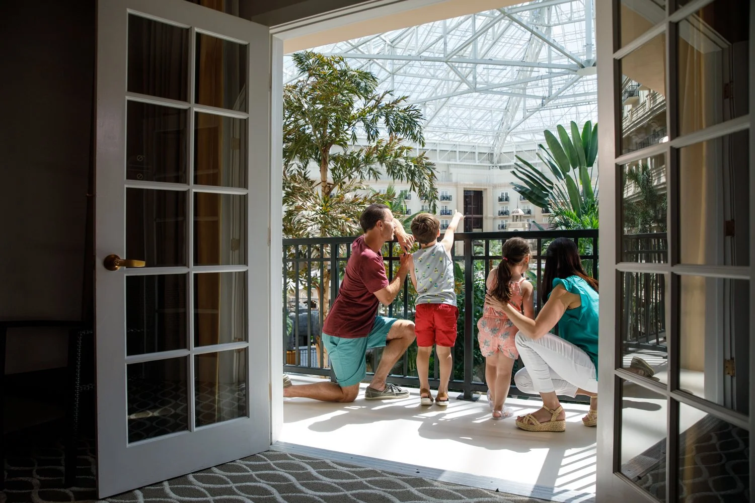 photograph of family looking out hotel balcony