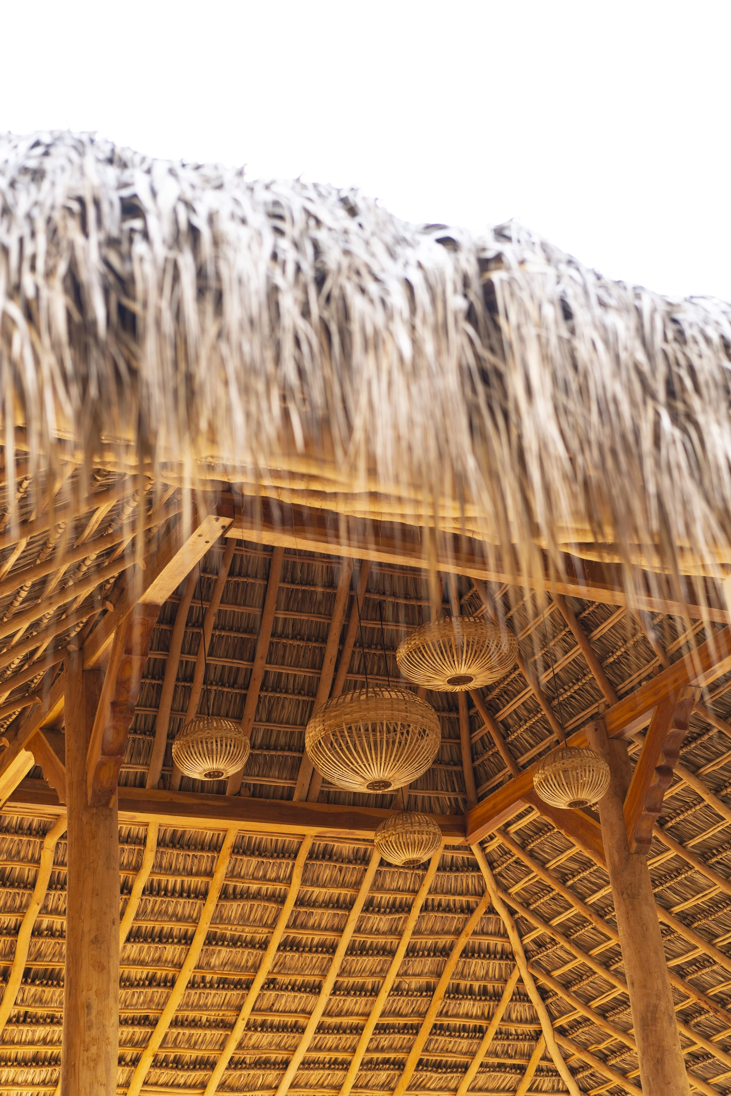 Soaring thatched roof with handwoven bamboo lanterns inside the open-air yoga shala at Still Salty Escape in Nicaragua