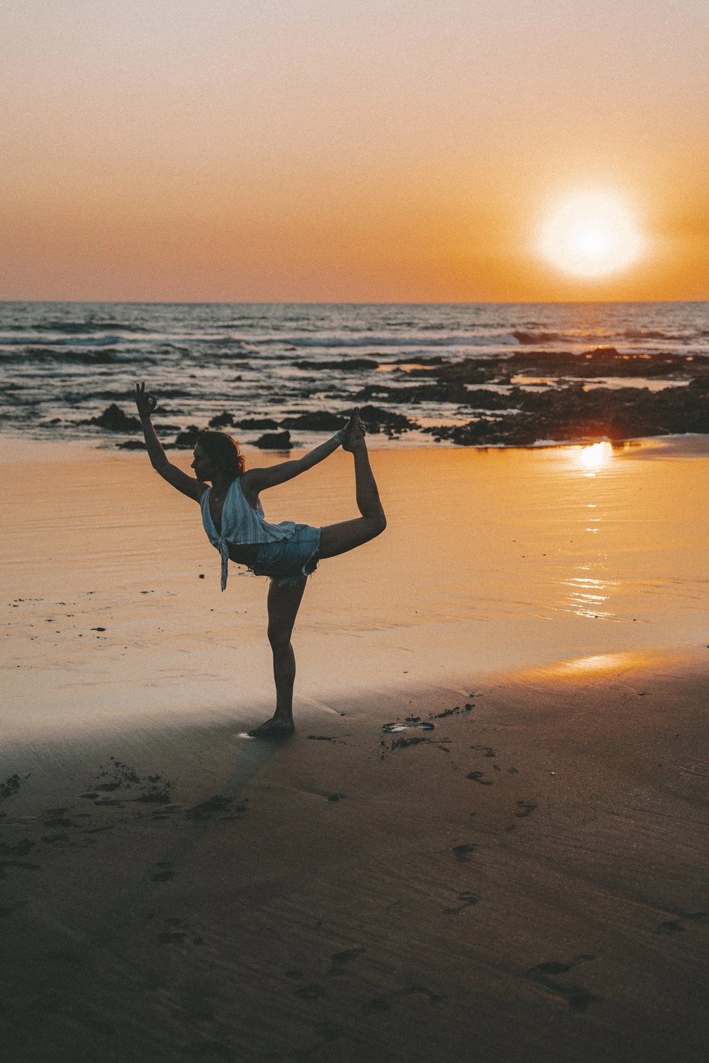 Woman in dancer's pose on the beach at sunset on Nicaragua's Pacific coast