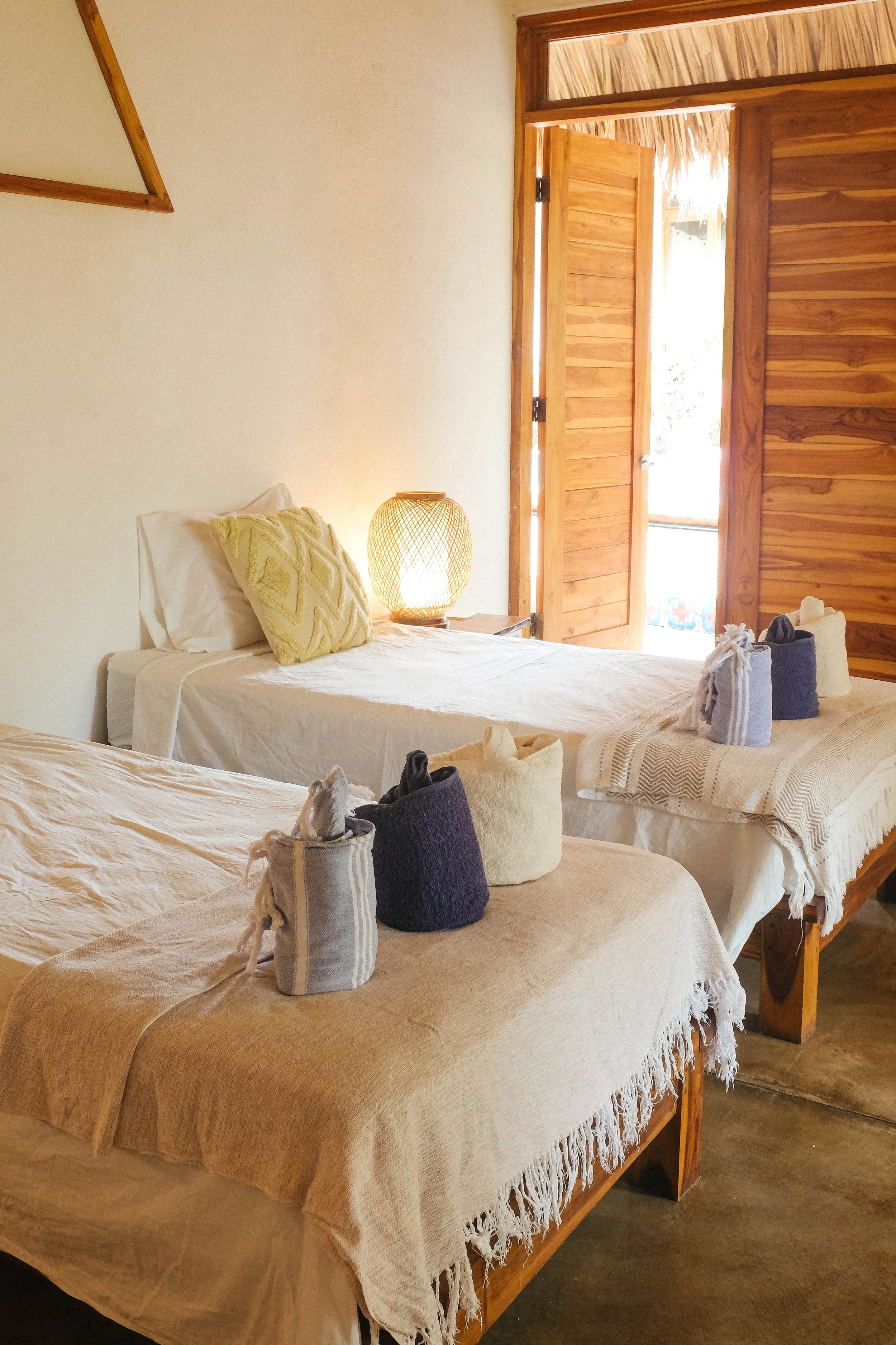 Two single beds that combine into a king bed in an air-conditioned ensuite downstairs cabaña at Still Salty Escape in Nicaragua