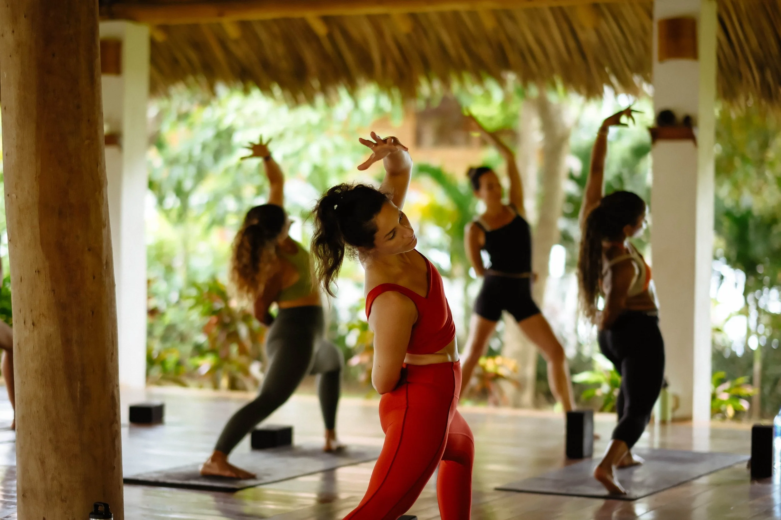 Group practicing yoga in an open-air shala on a surf and yoga retreat in Nicaragua