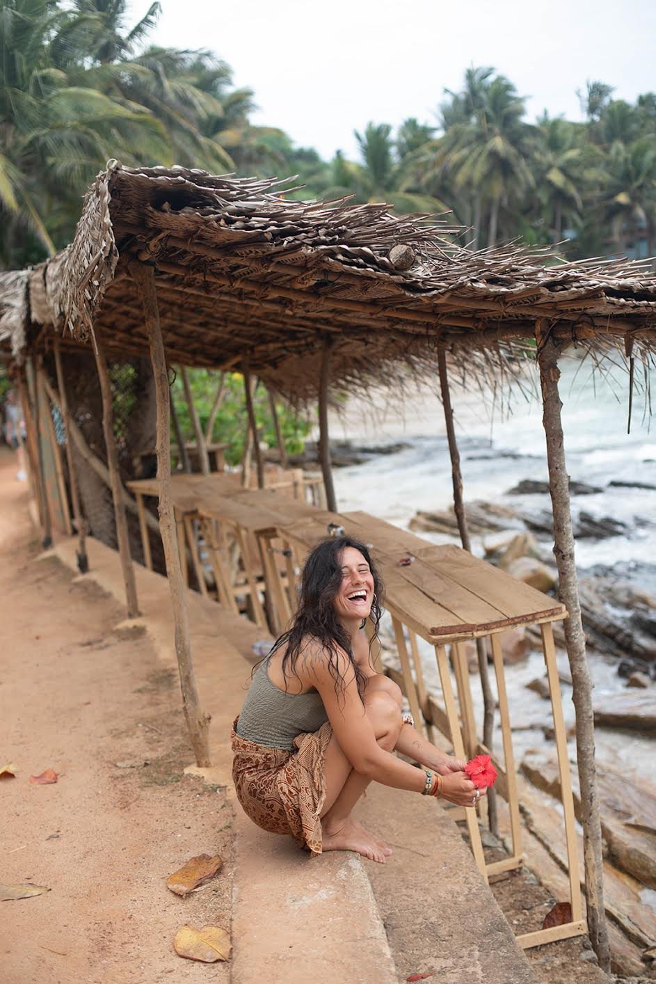 Mariana, yoga teacher, sitting under a palapa and smiling ahead of her Atma Yoga Retreat in Nicaragua