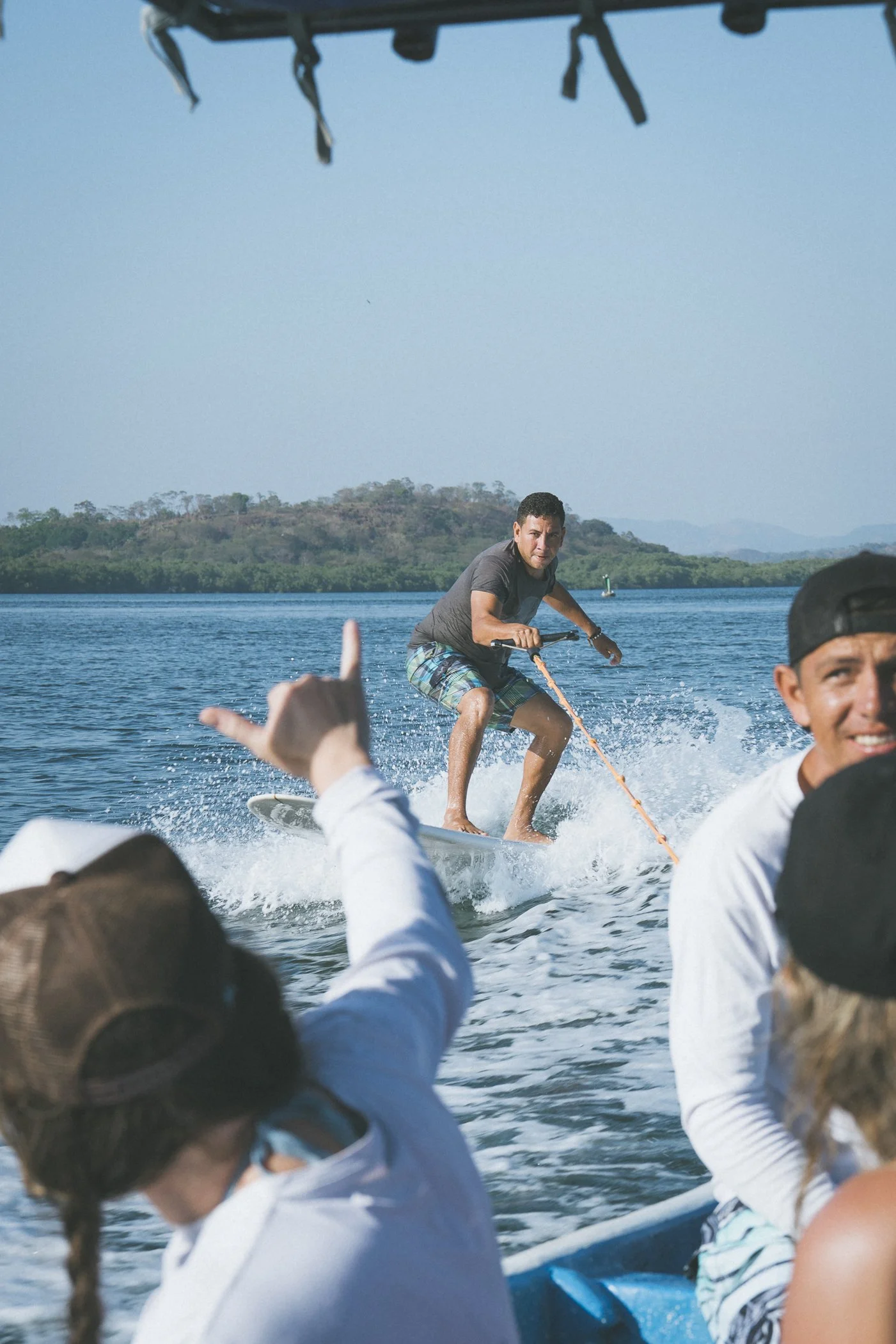 Local guide wake surfing behind the boat during a mangrove tour in northern Nicaragua
