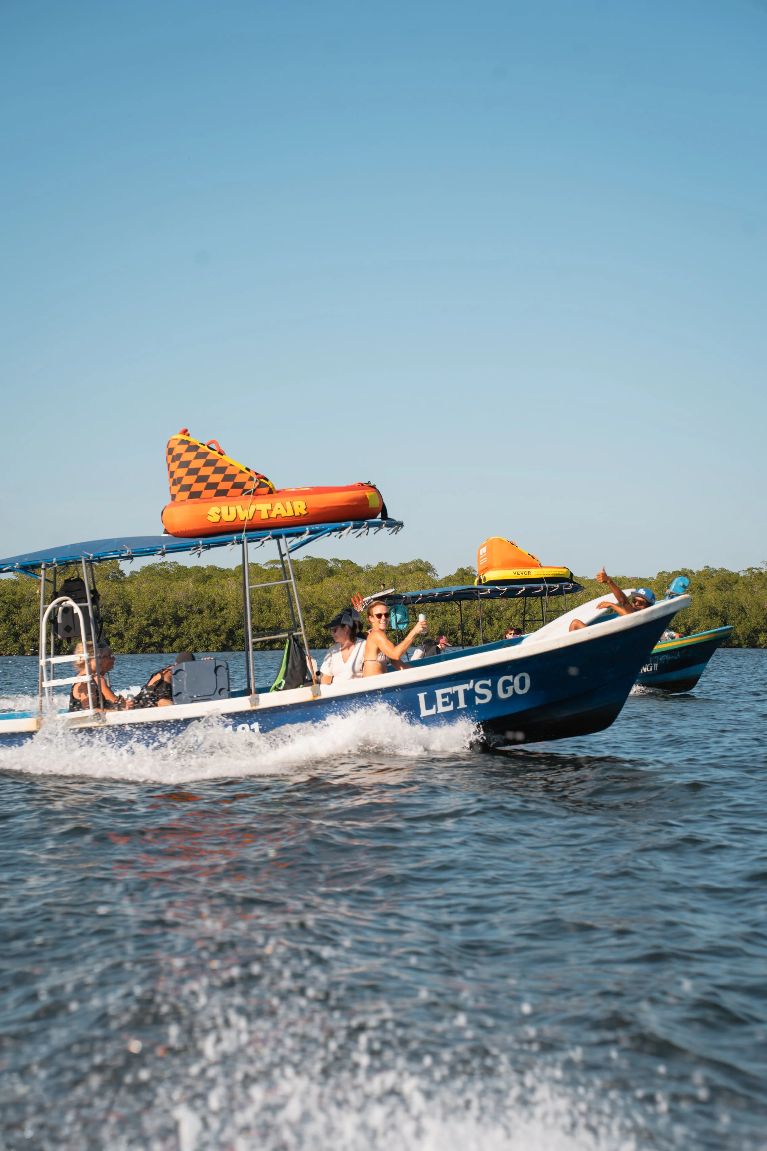 Guests riding pangas loaded with tubing gear through the mangroves on a boat tour in Nicaragua