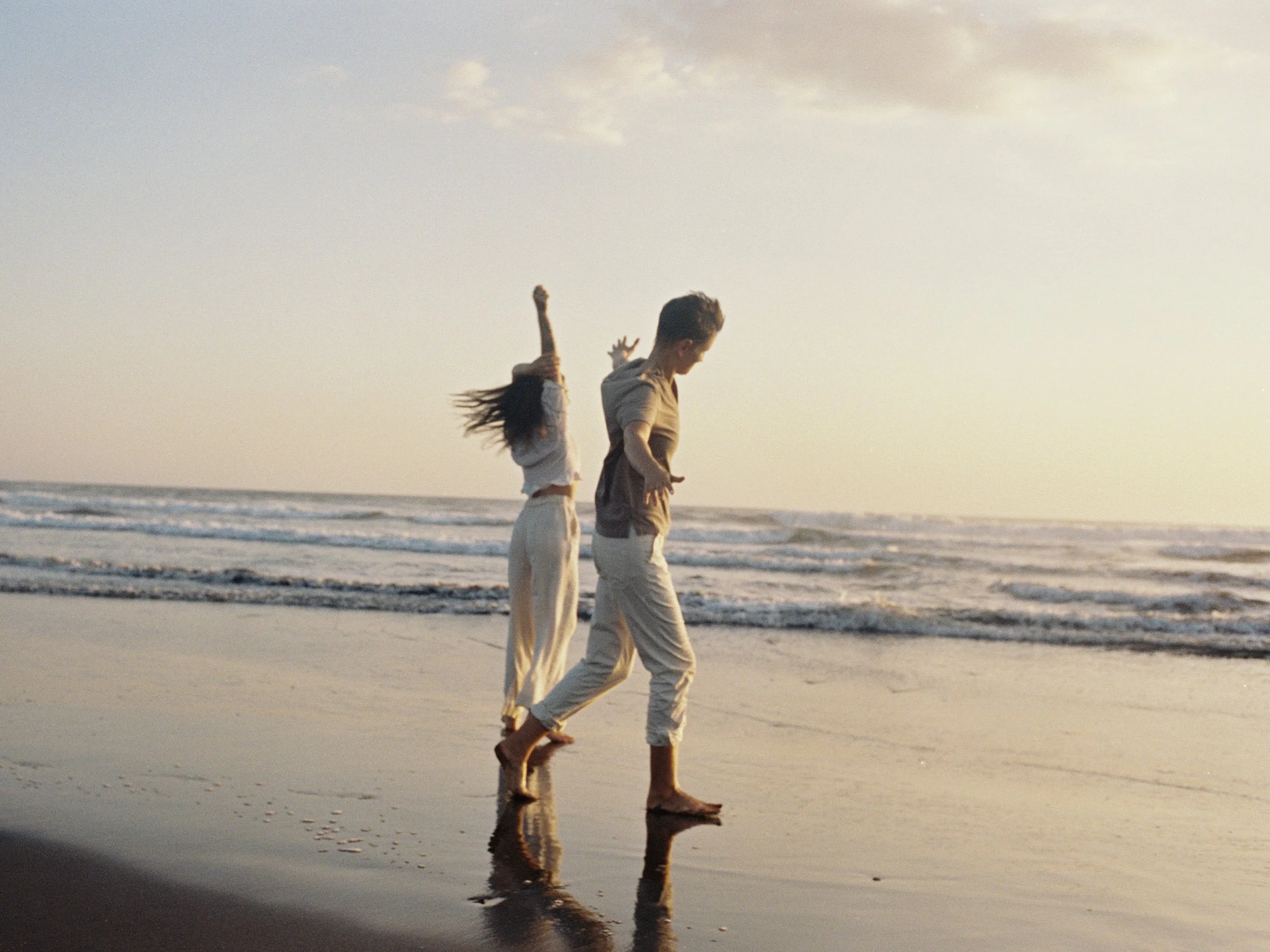 Couple dancing playfully on the beach at sunset during a couples retreat in Nicaragua