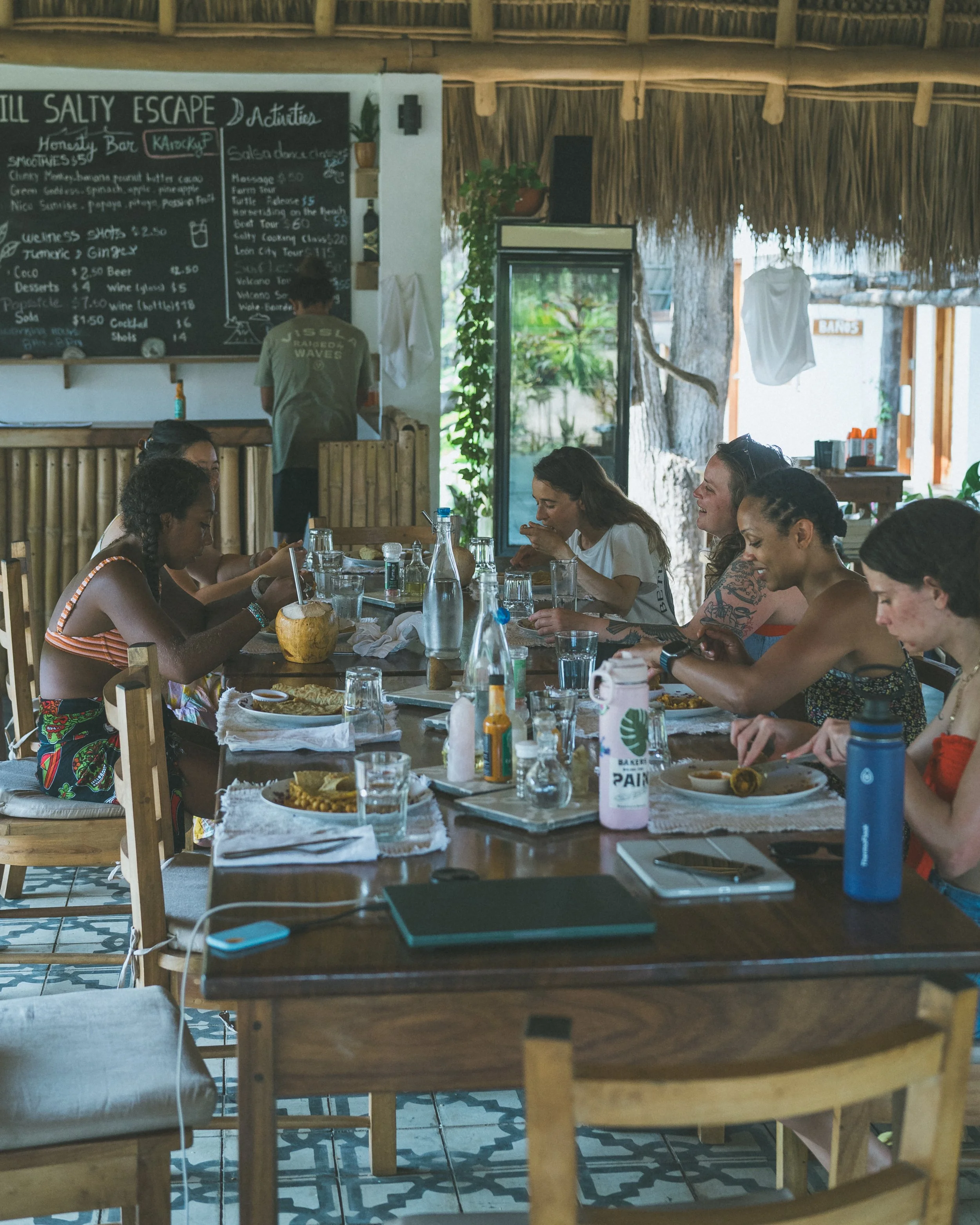 Retreat guests sharing a farm-fresh meal at the communal table at Still Salty Escape in Nicaragua