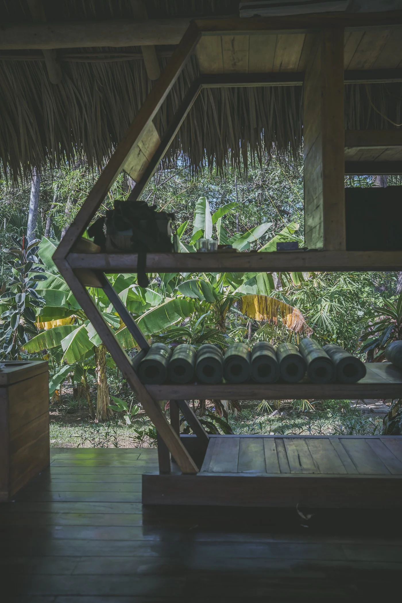 Handmade hexagon shelf holding rolled yoga mats with a jungle view in the open-air shala at Still Salty Escape Nicaragua