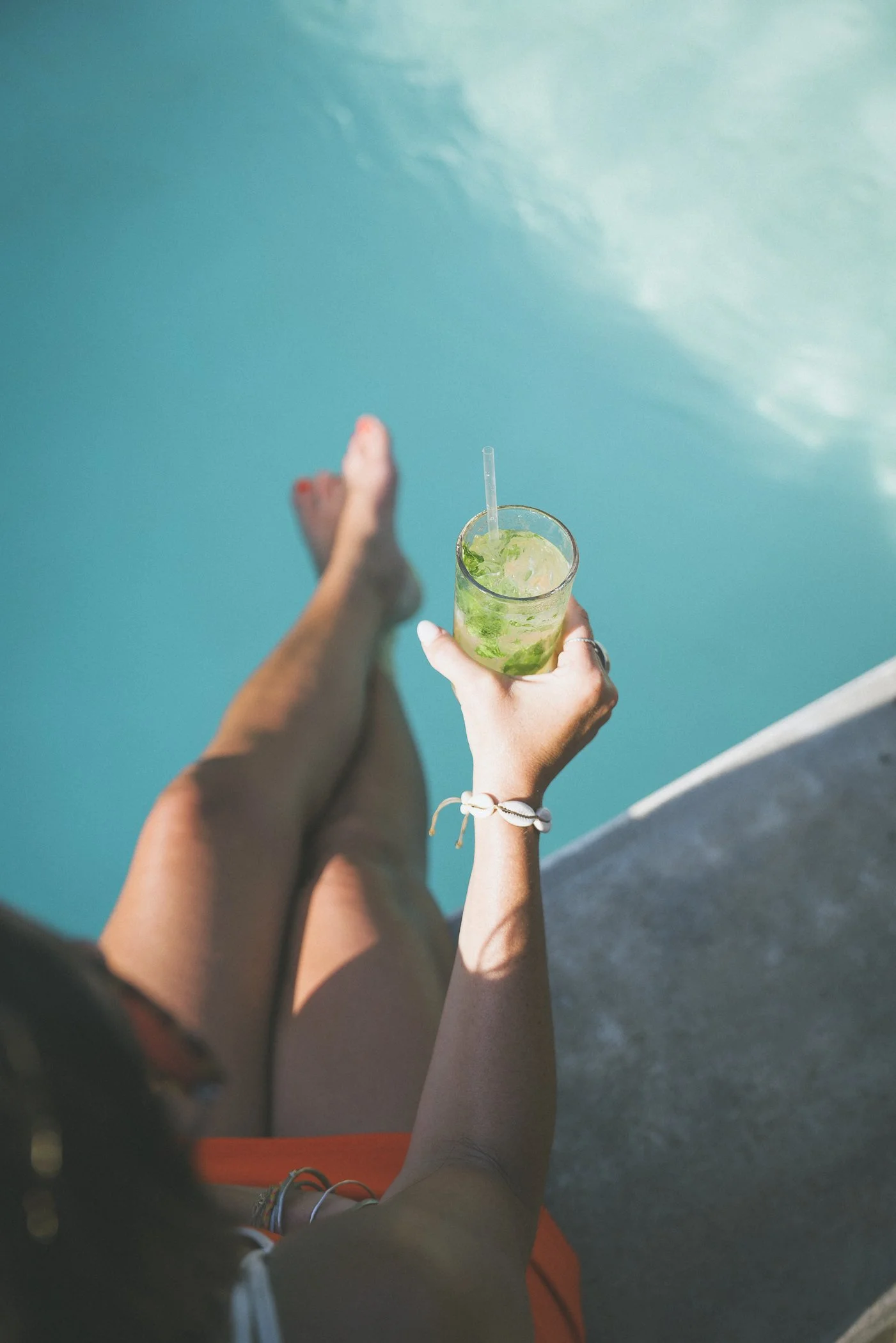 Guest relaxing poolside with a fresh mint mocktail at an alcohol-free retreat in Nicaragua
