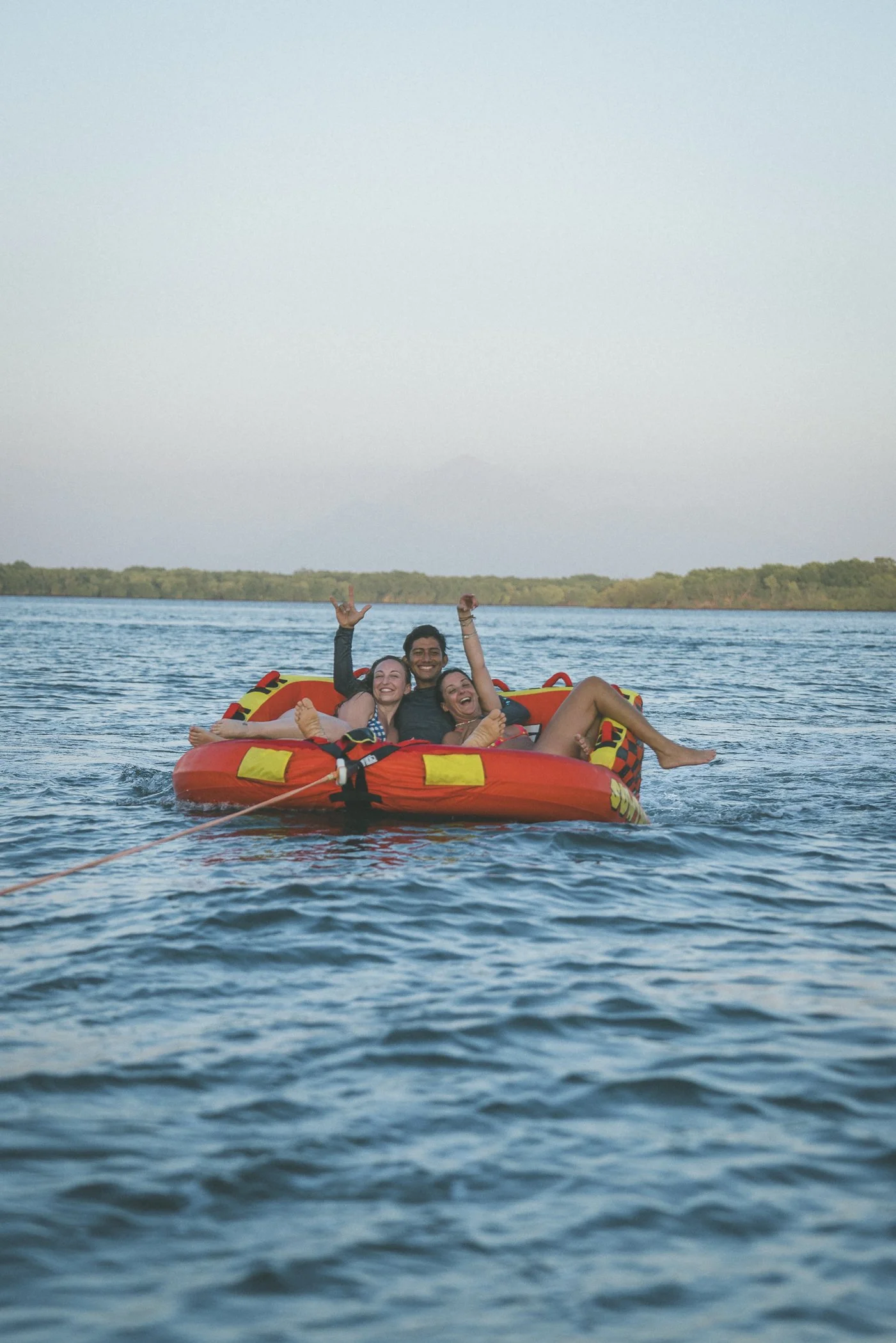 Three guests laughing on a towable tube during an active adventure retreat in Nicaragua