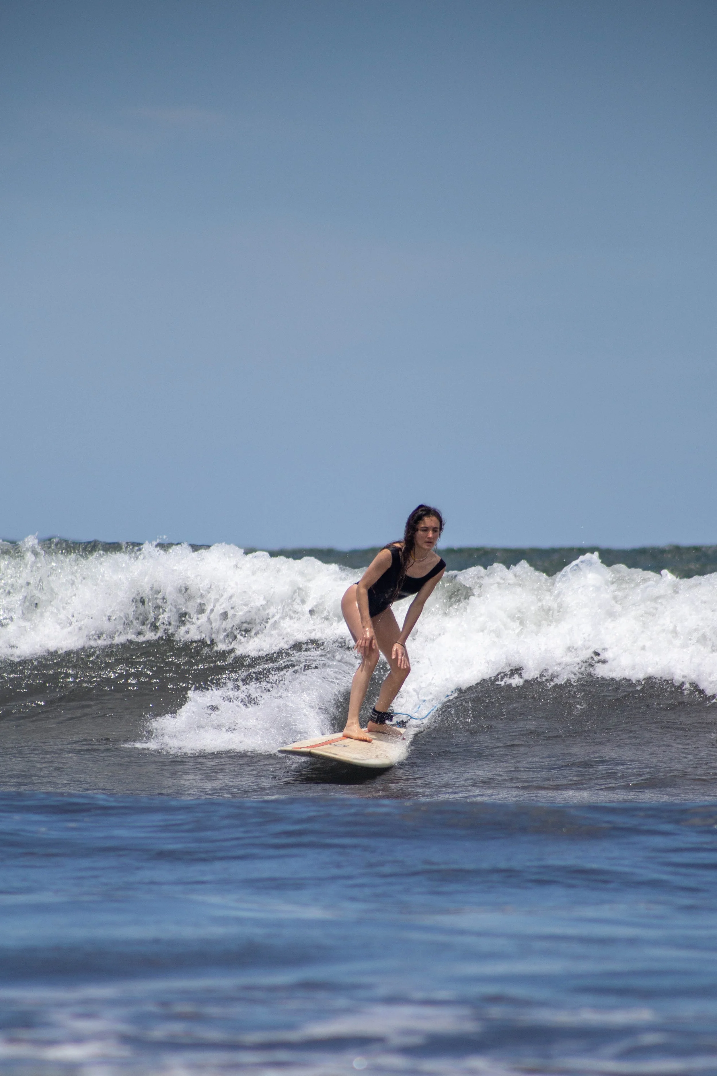 Surfer riding a green wave with improved stance after lessons, showing progress learning to surf in Nicaragua