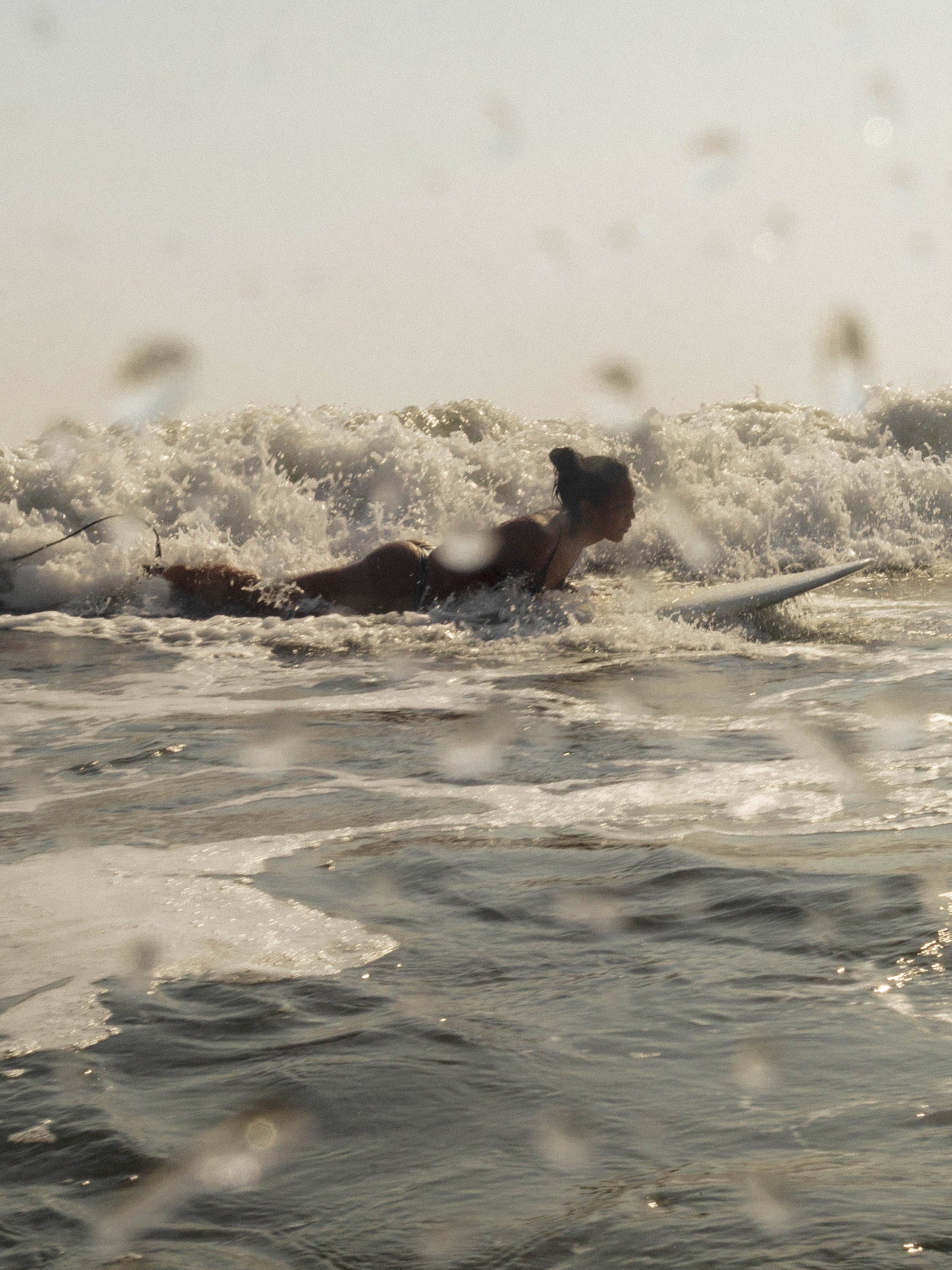 Woman paddling into a wave on an uncrowded Pacific break at a surf retreat in Central America