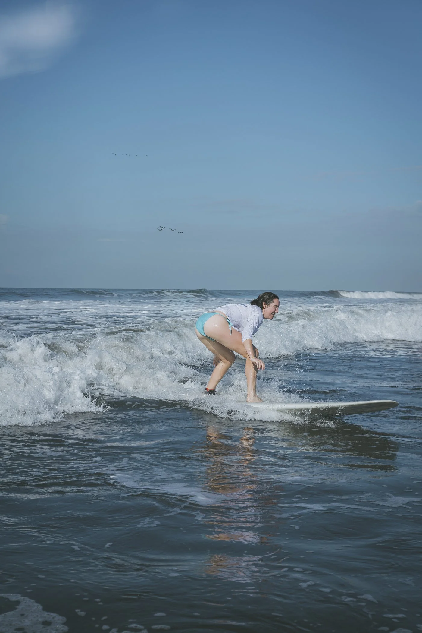 Beginner surfer riding a small wave on a longboard at an all-levels break near Still Salty Escape surf camp in Nicaragua