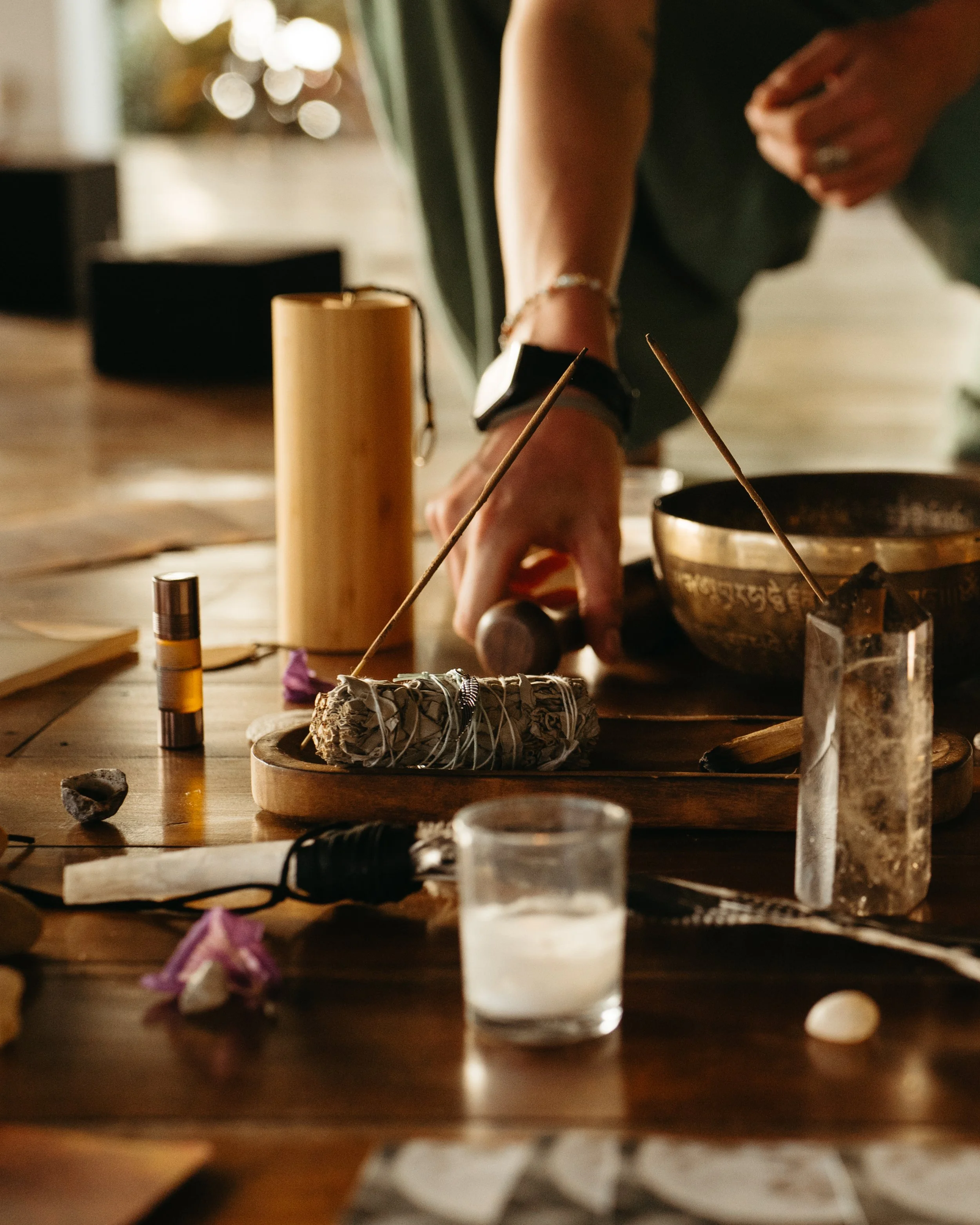 Facilitator preparing a ceremony altar with sage, crystals, and a singing bowl at a breathwork retreat in Nicaragua