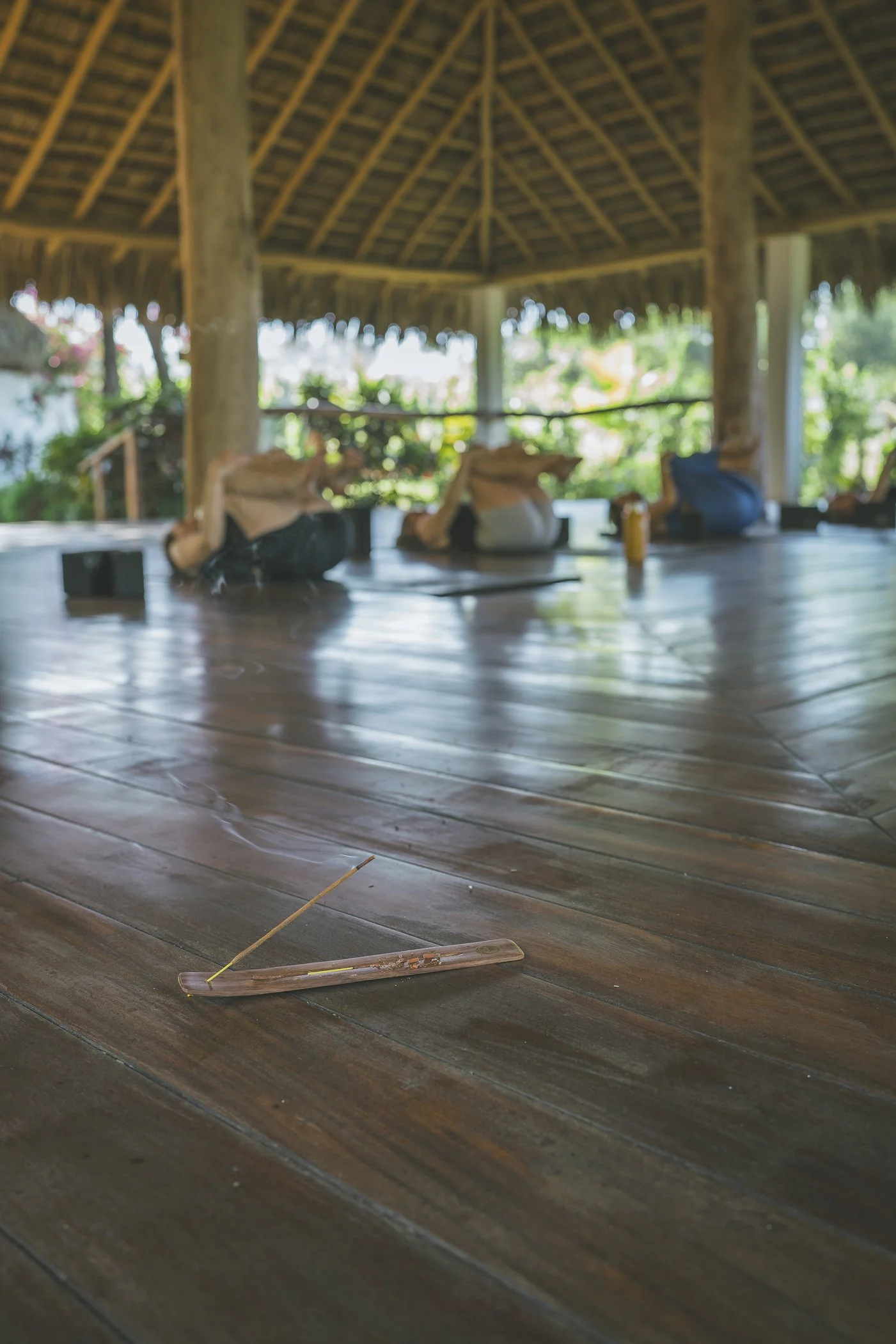 Incense smoking on the shala floor as participants rest in savasana during a sound bath at a retreat in Nicaragua