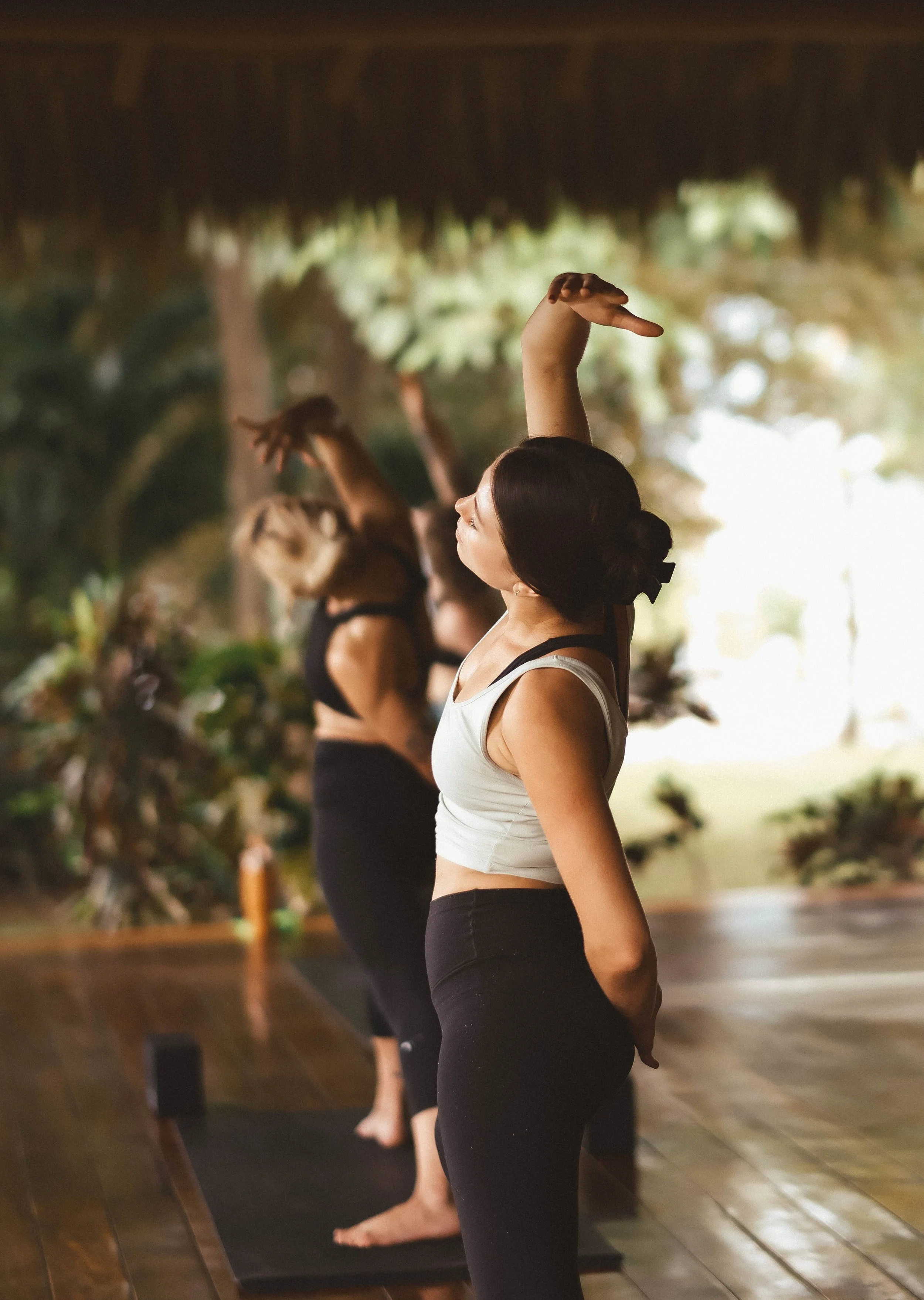 Small group practicing yoga together in an open-air shala at a surf and yoga retreat in Nicaragua