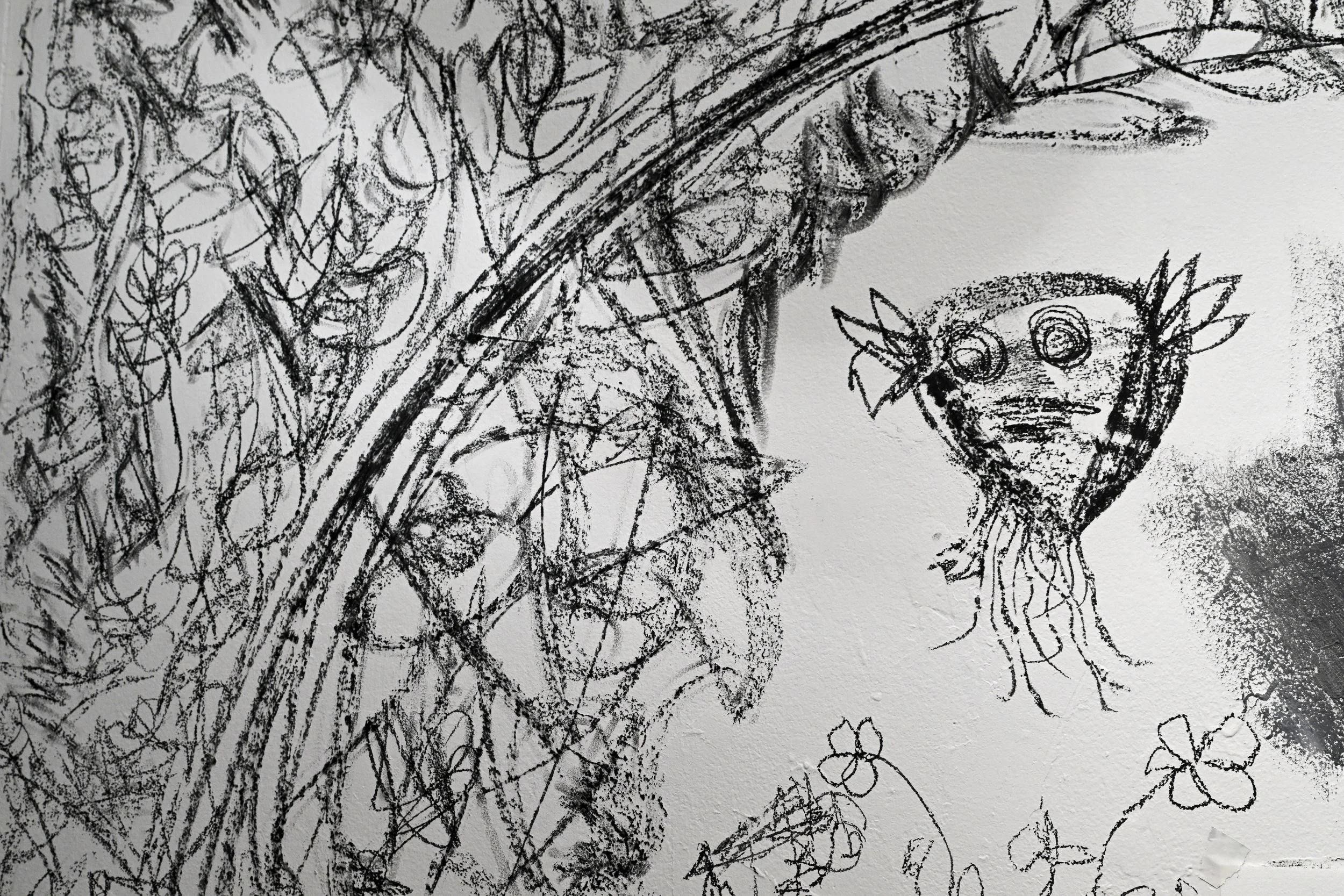 A black and white sketch of a face on the left side and a small creature on the right side, surrounded by flowers and abstract lines.