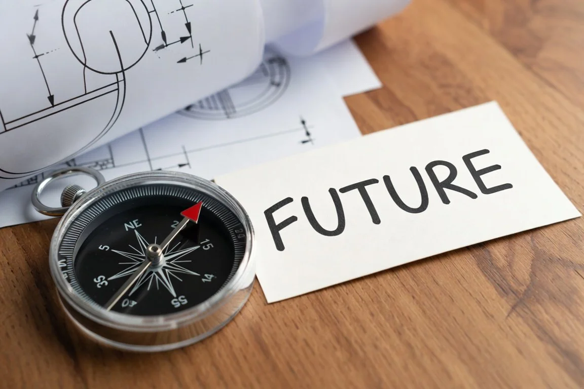 Compass on wooden table pointing toward a bright future career path with blueprint elements, symbolizing strategic job search targeting, finding the right employers, and gaining career direction with ADHD.