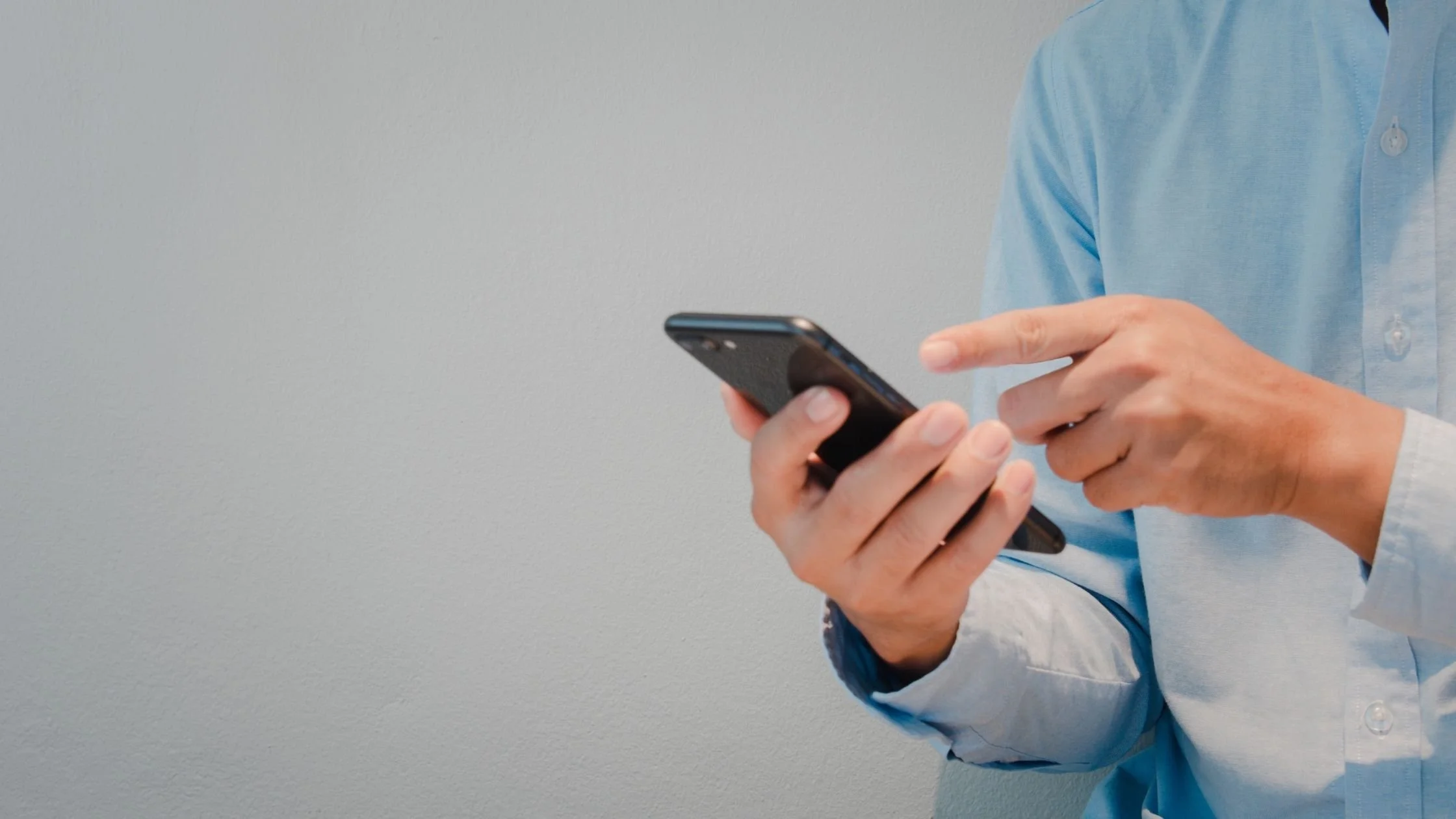 a man wearing smart casual outfit using mobile phone