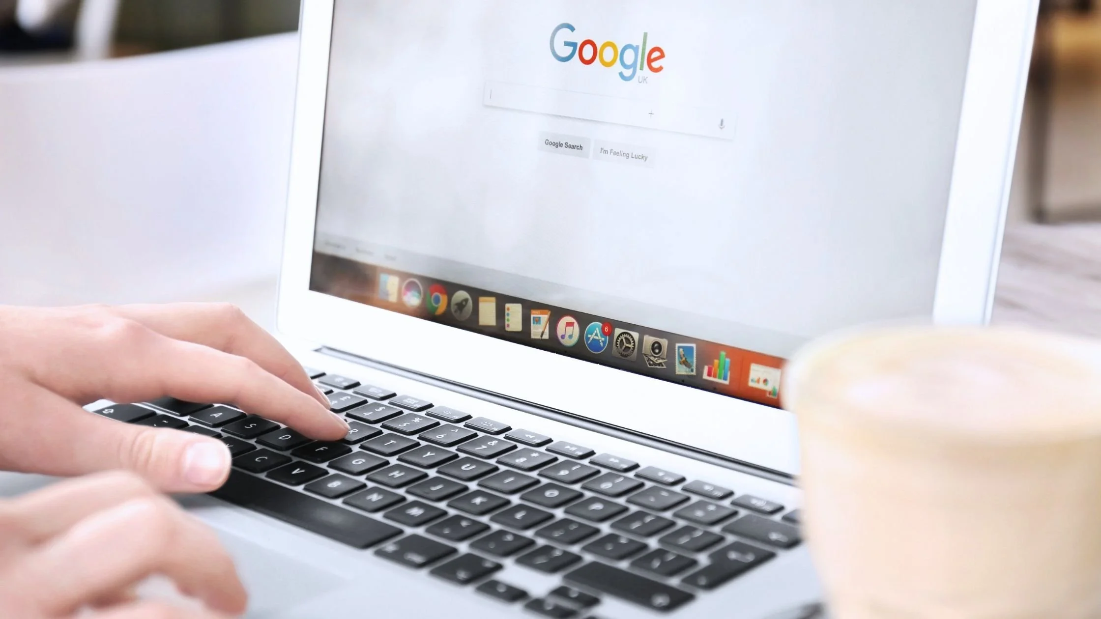 using laptop to search on google while on a coffee shop