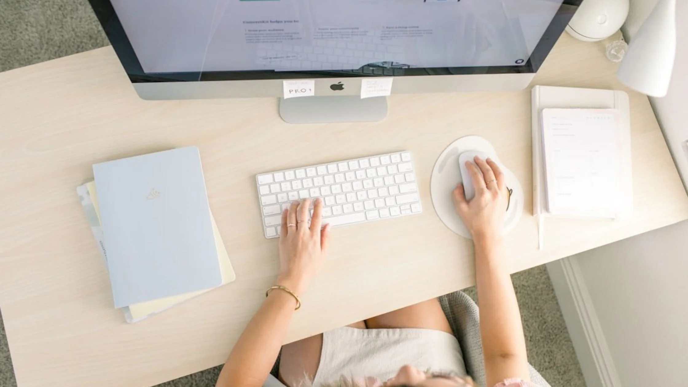 woman sitting at her minimal and clean office desk using the computer