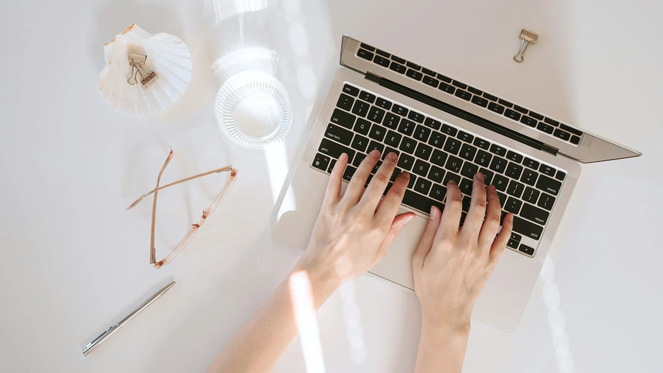 woman typing on her laptop minimalist elegant white desk
