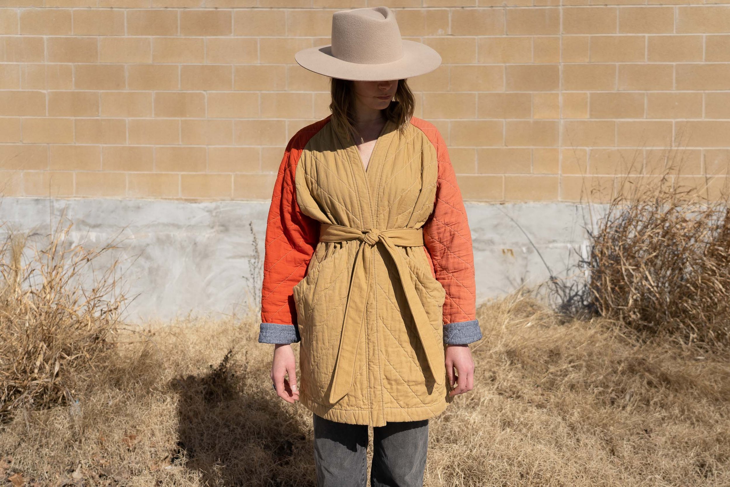 woman wearing camel red and pink cotton quilted coat with a camel tied belt