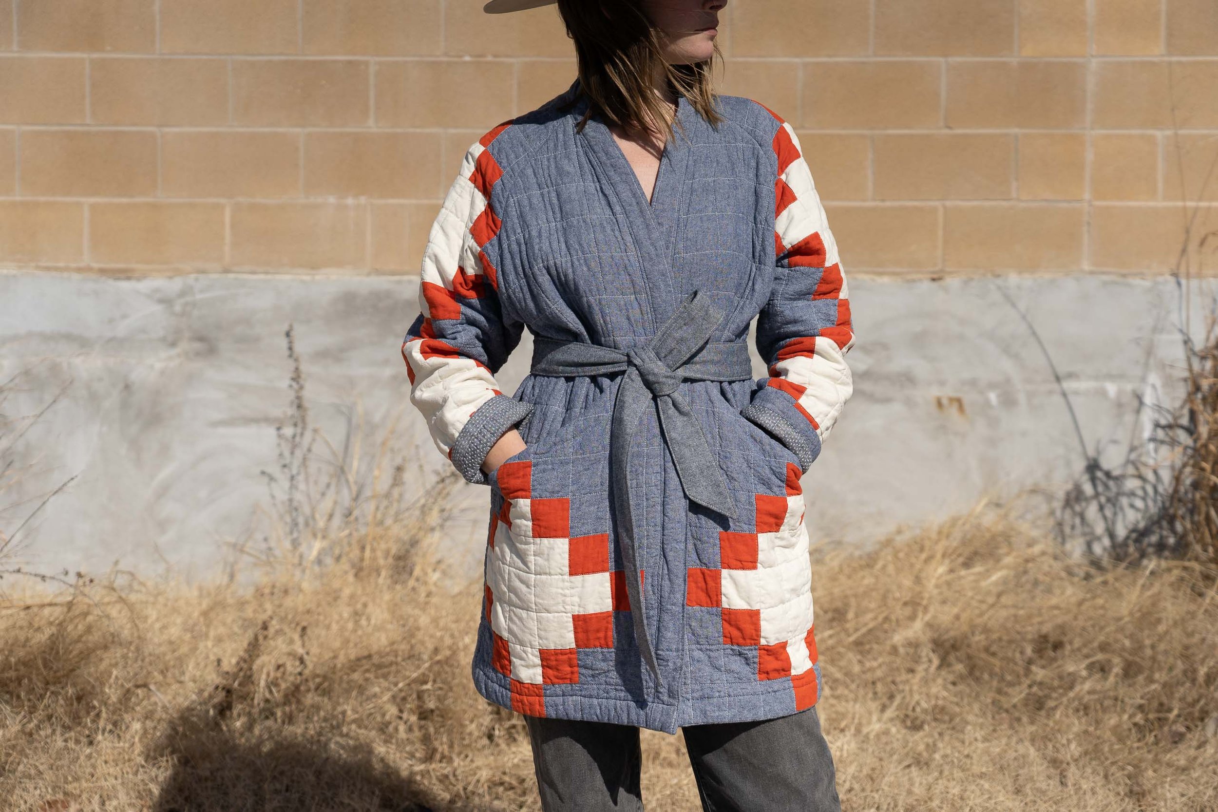woman wearing blue red and white southwestern quilted coat with a tied belt