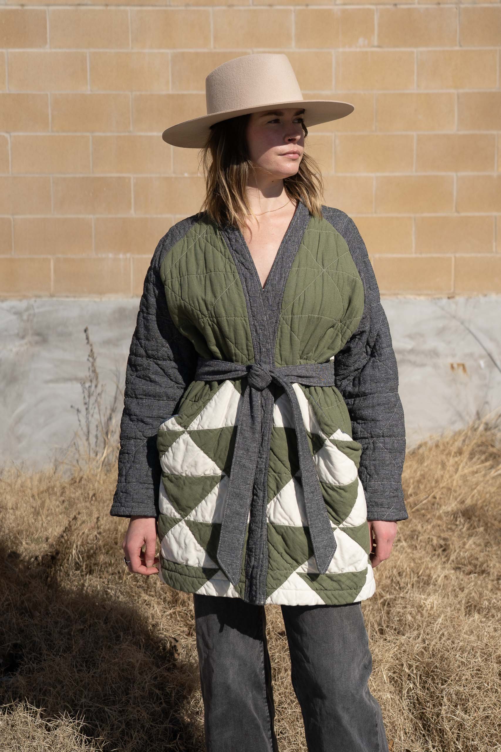 woman wearing green white and grey cotton and linen quilted coat with a grey tied belt