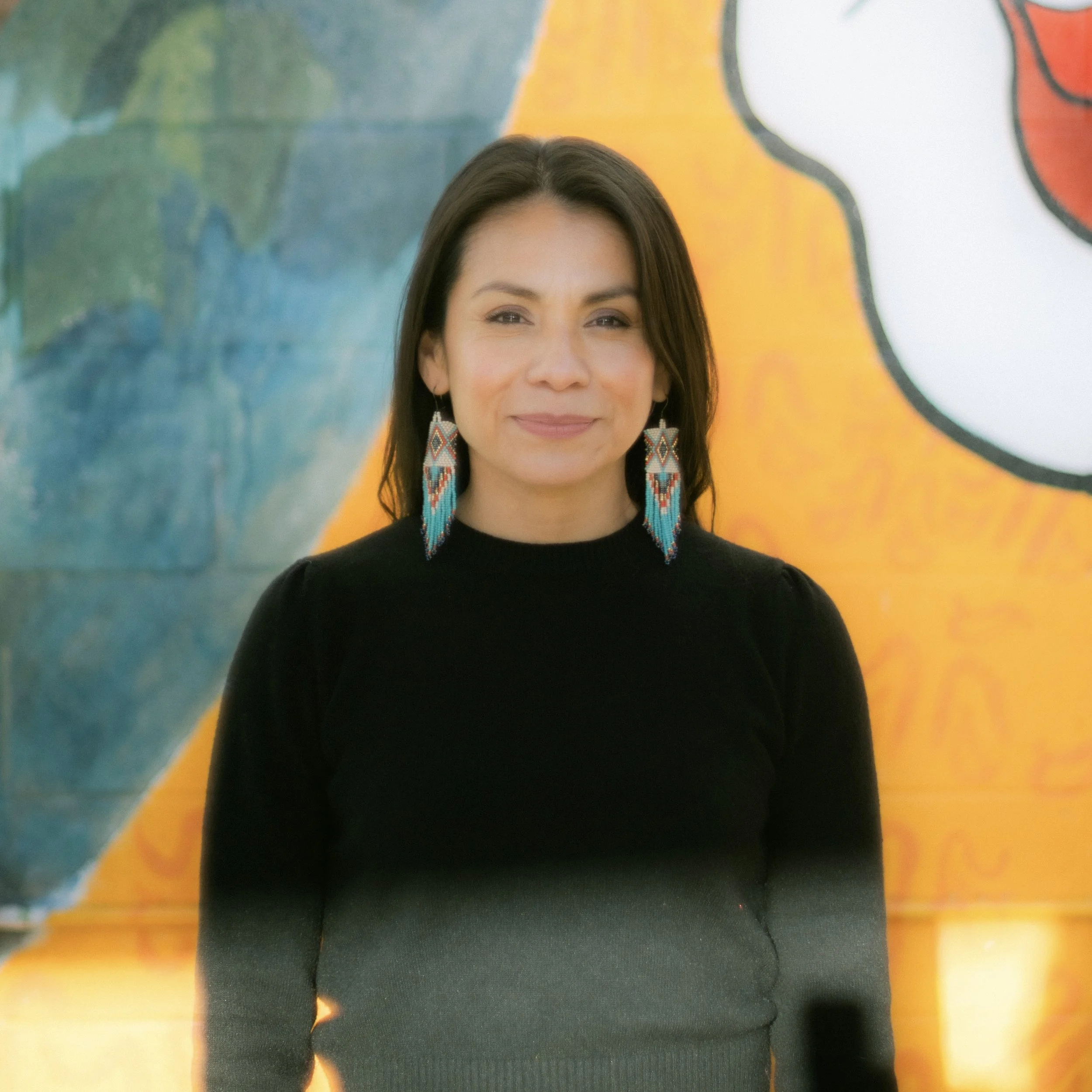 Artist posed in front of mural