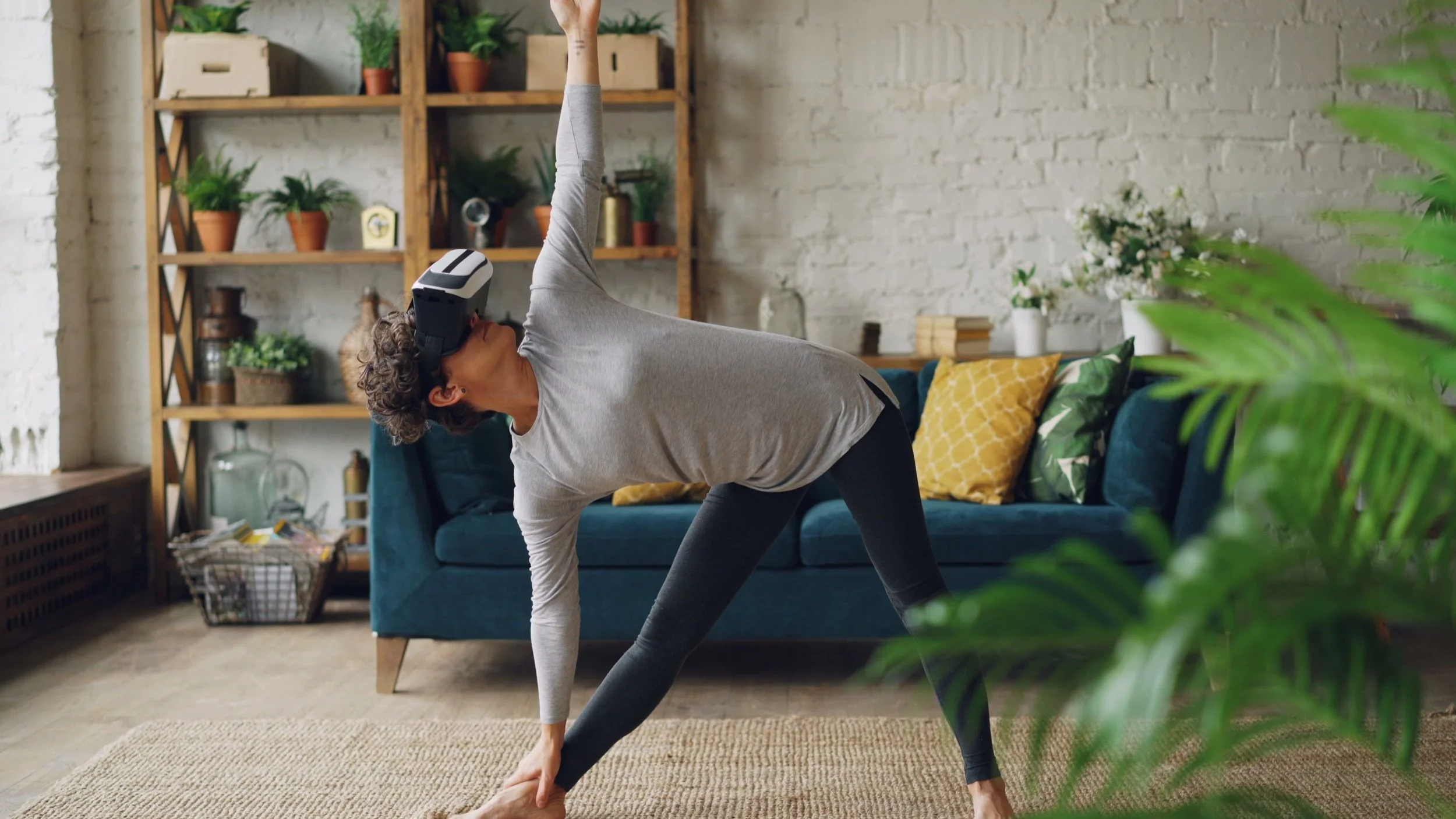 Person doing a standing yoga pose at home while wearing a virtual reality headset