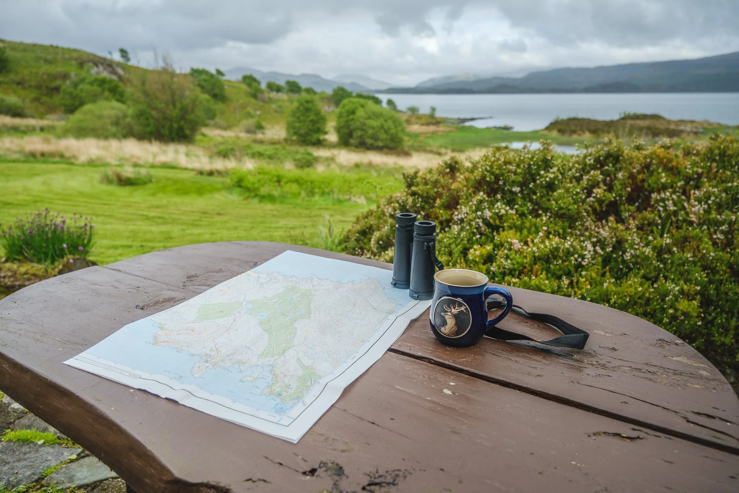Seating area outside iwth map and binoculars. Camas bàn cottage, self catering cottage for 2 -4 people on the shorefront of Loch Sunart, Ardnamurchan (Copy)