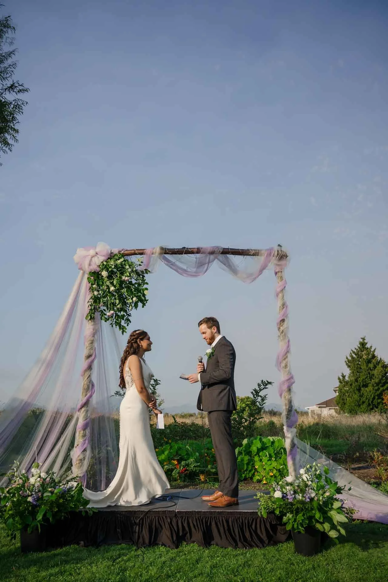 bride and groom standing under decorated arch