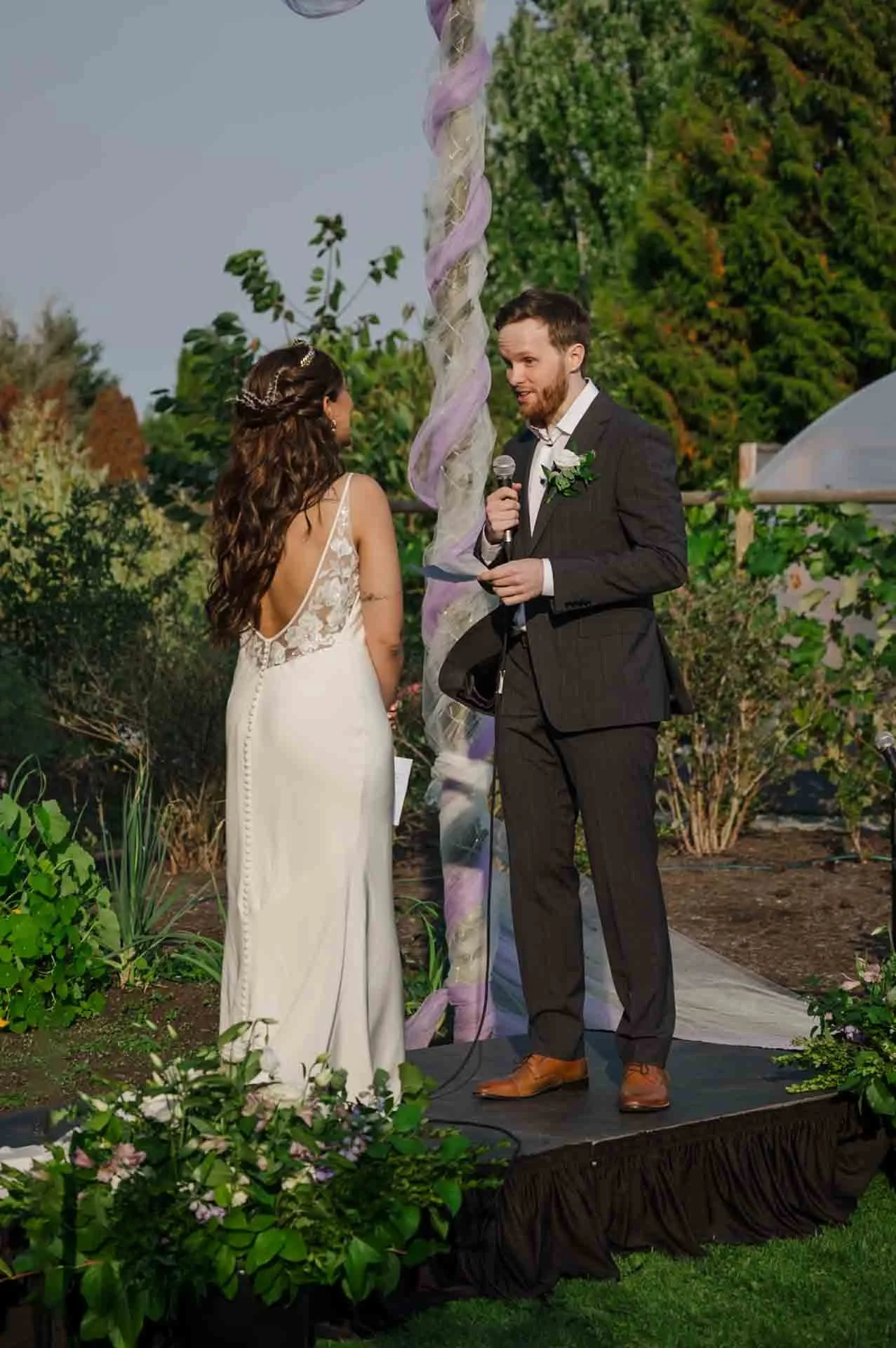 groom saying vows into a mic to bride