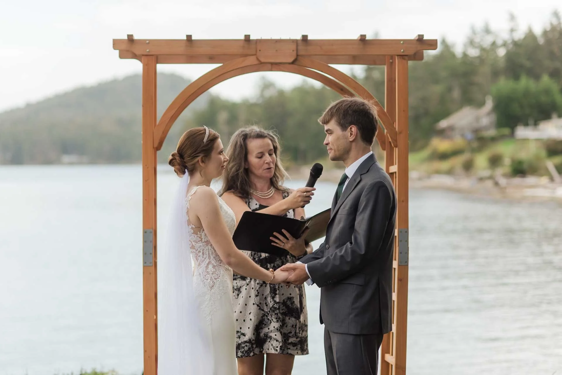 wedding officiant holding mic for groom as he says his vows