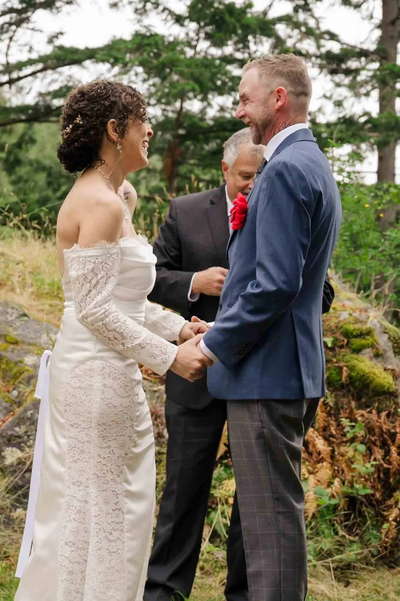 bride and groom holding hands smiling at each other