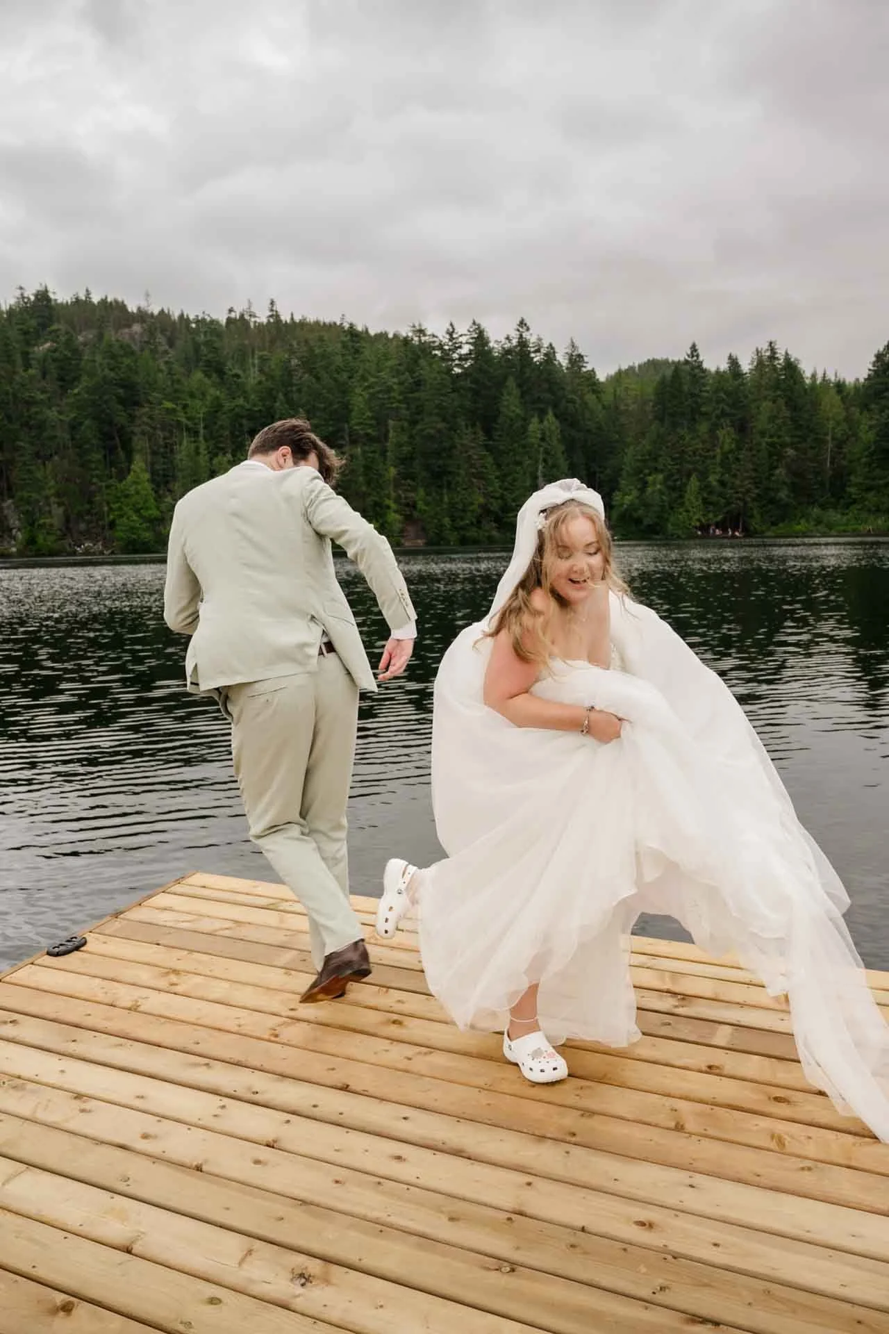 bride and groom dancing on a floating dock in the middle of a lake