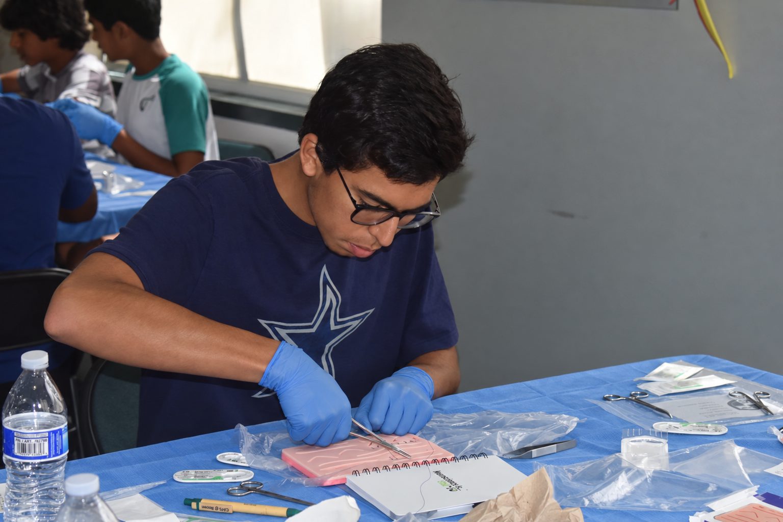 Student suturing workshop with blue gloves-6.png