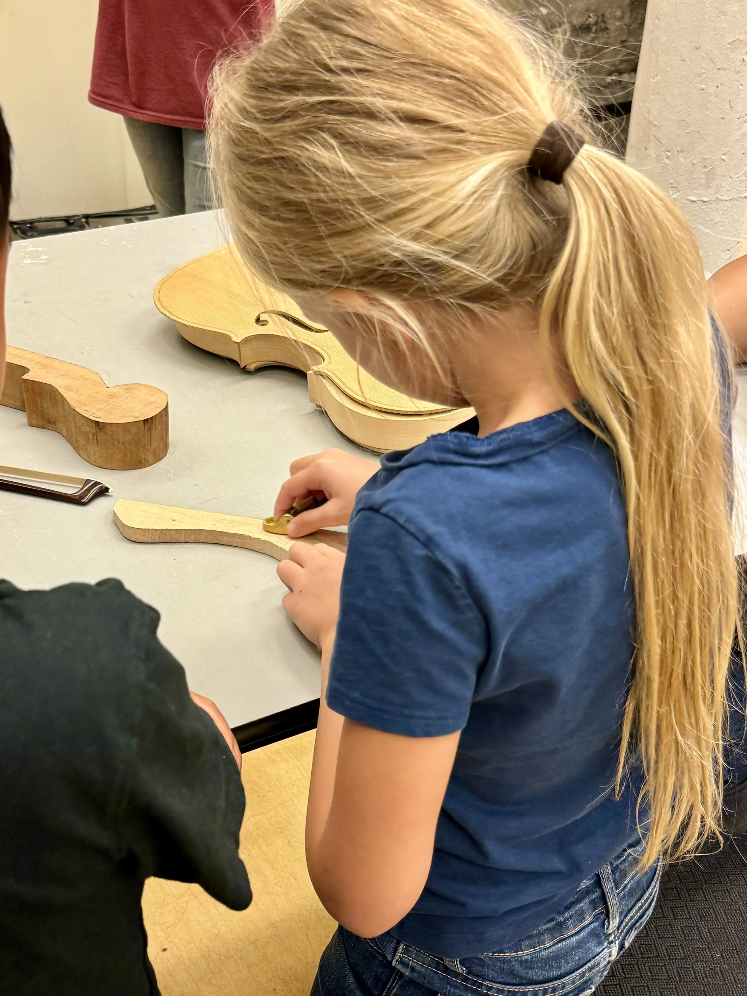 AYAP student learning about the violin parts to better understand the instrument.