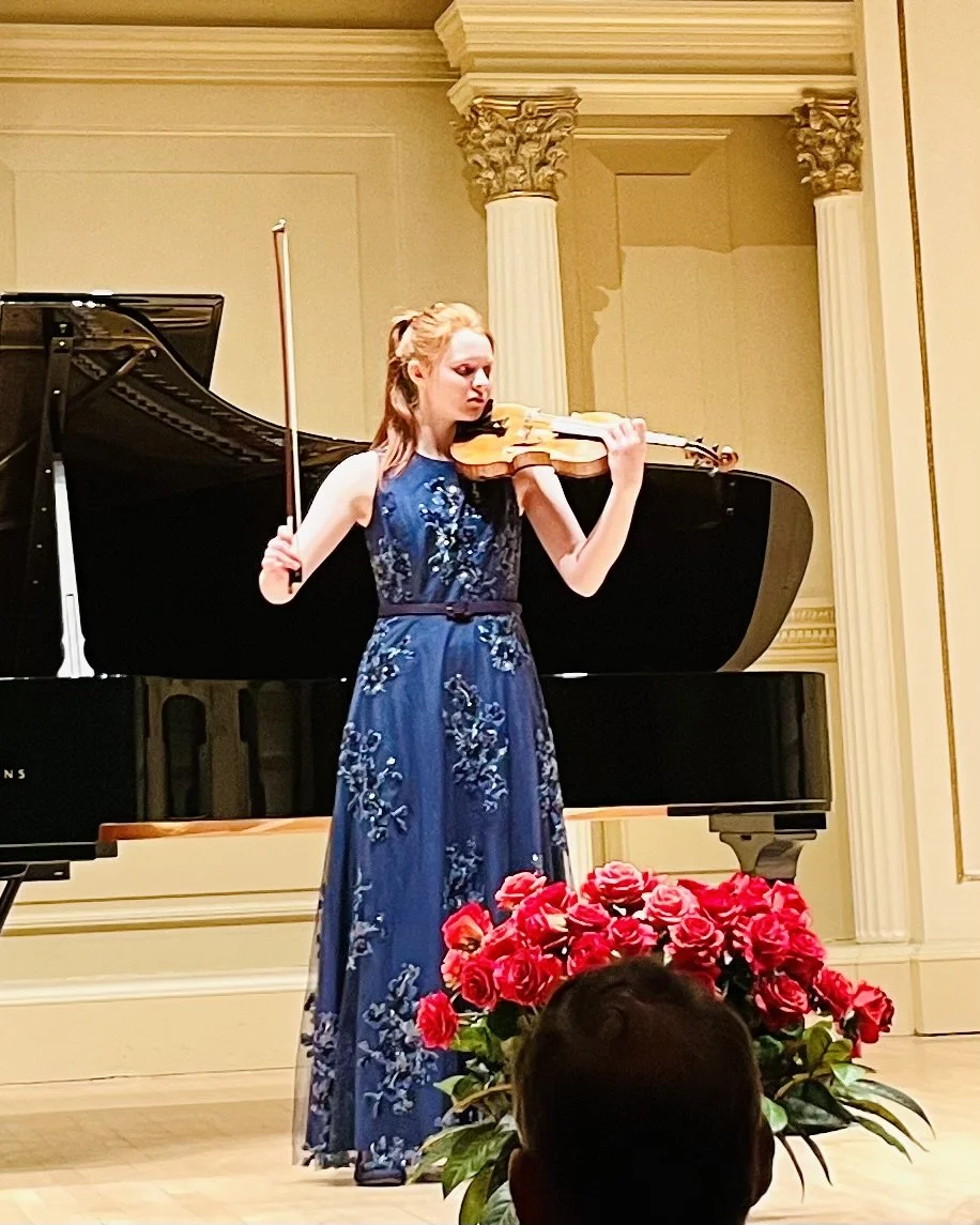 Advanced pre-college violin student performing solo at a major recital or competition.