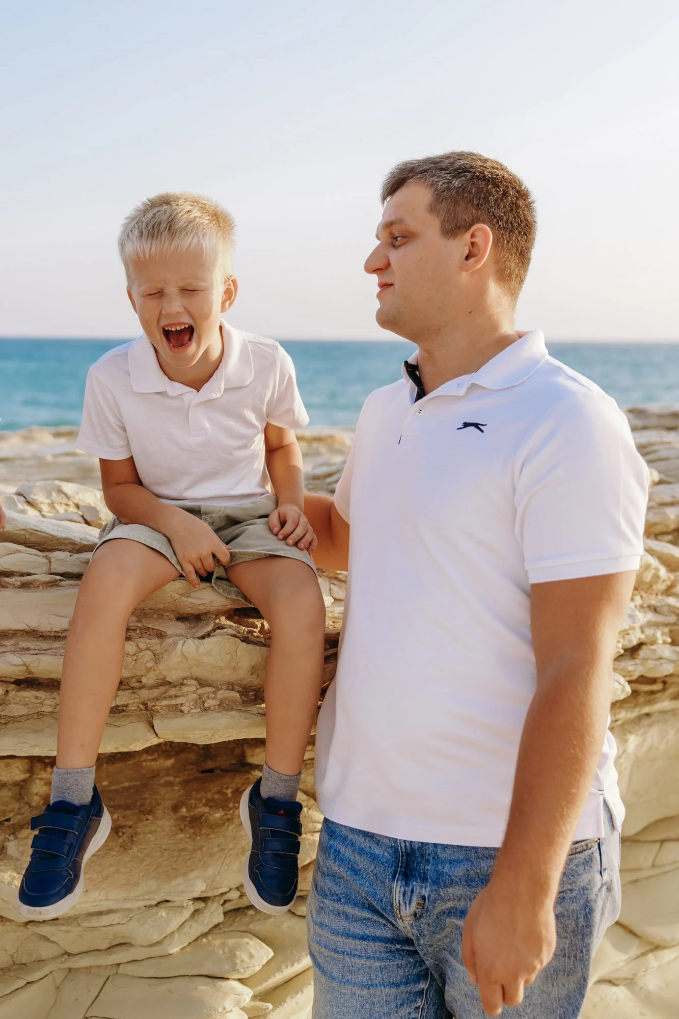 father and child laughing during White Stones Limassol family photoshoot by the sea