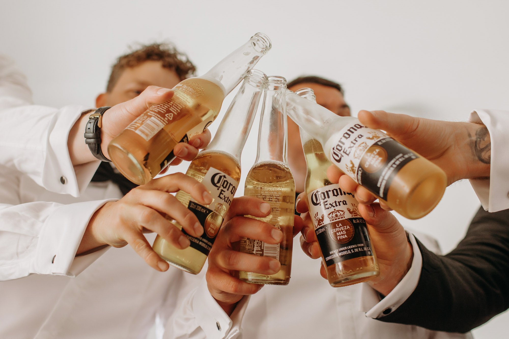Group of people toasting with bottles of Corona Extra beer