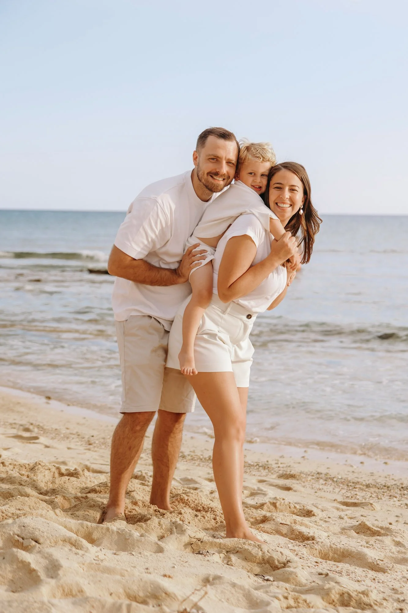 family walking together on Ayia Napa beach during sunset photoshoot Cyprus