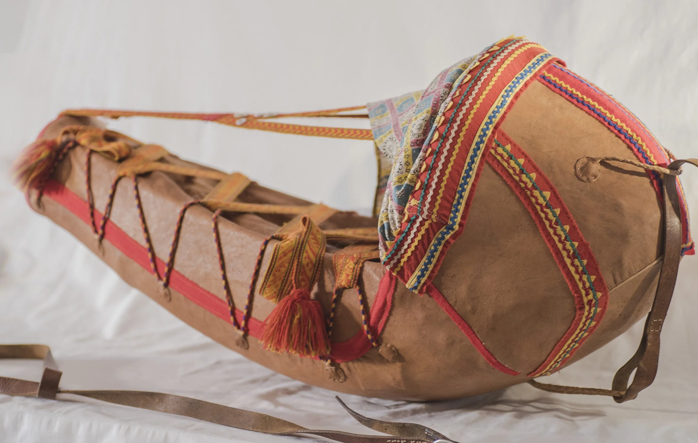 This beautifully crafted cradle is a traditional Sámi giehtkka — a wooden cradleboard used by Sámi families of northern Scandinavia to carry and protect their babies. Carefully shaped and richly decorated, this example is adorned with vibrant woven b