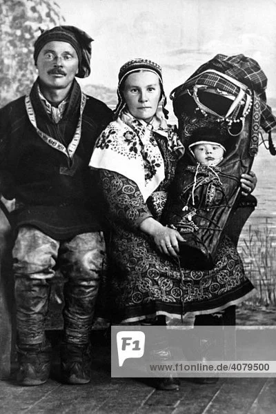This striking portrait of a Sámi family showcases the deep cultural roots and skilled craftsmanship of northern Scandinavia’s Indigenous people. The mother holds her baby in a beautifully decorated komse (also called gahkku or cradleboard), tradition