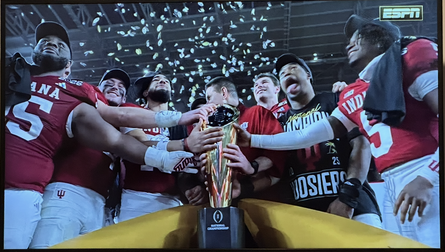 IU football team holds championship trophy surrounded by confetti