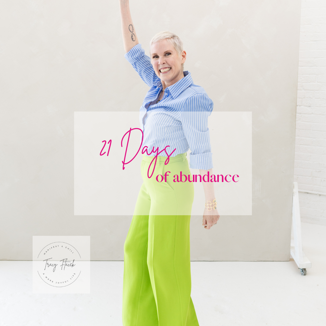 A woman with short blonde hair smiling and raising one arm, wearing a blue striped shirt and bright green pants. Text overlay says '21 Days of abundance.'
