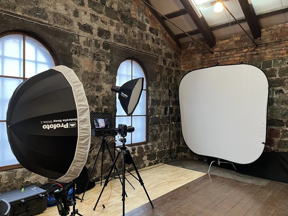 Photo studio with lights and backdrop set up in a room